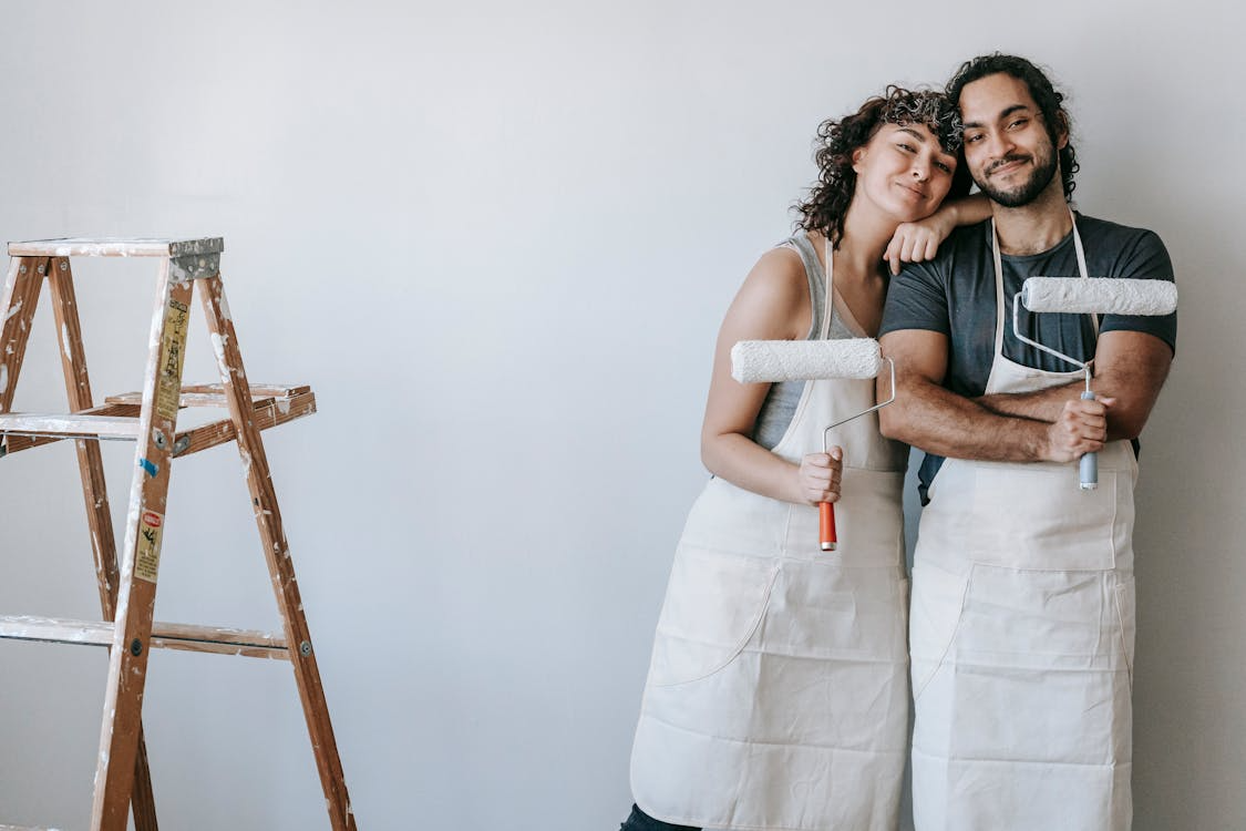 couple holding paint rollers