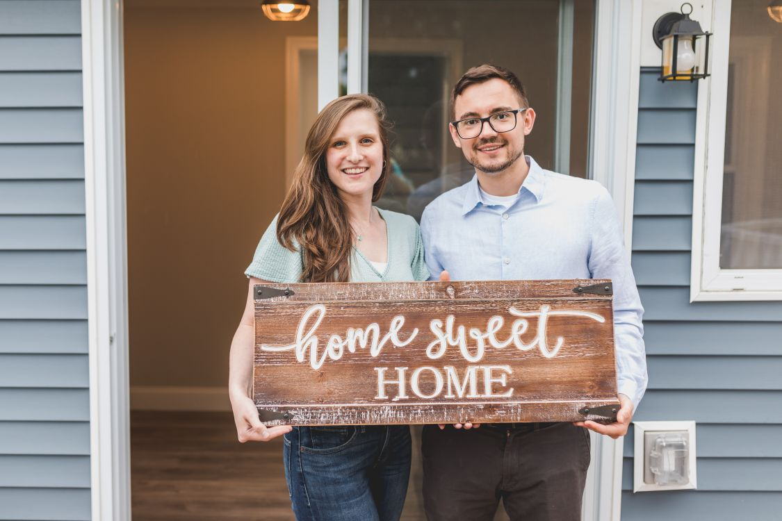 Happy couple standing in front of their new home