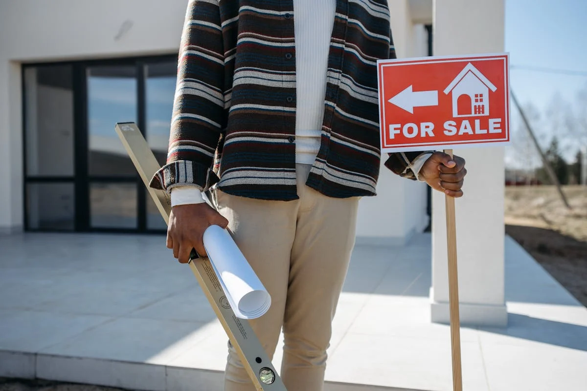 man holdin materials and for sale signage