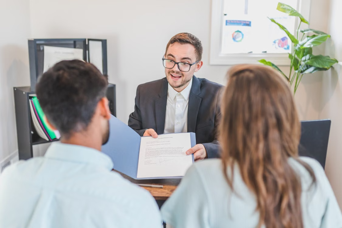  Questions to ask a mortgage lender: couple reviewing paperwork with a broker