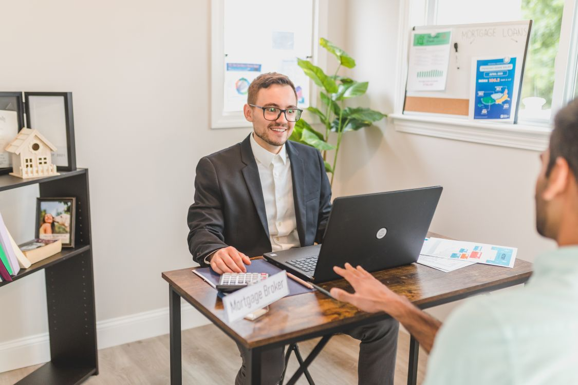 Questions to ask a mortgage lender: broker showing interest rate trends to a client