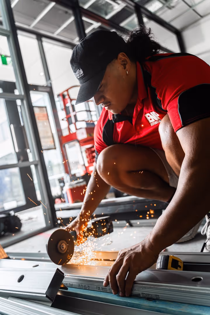 Commercial construction worker using a saw, representing hands-on craftsmanship and build projects.