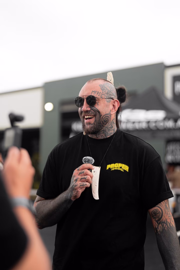 Tattooed arm using a red power drill, symbolising craftsmanship and hands-on work in commercial projects.