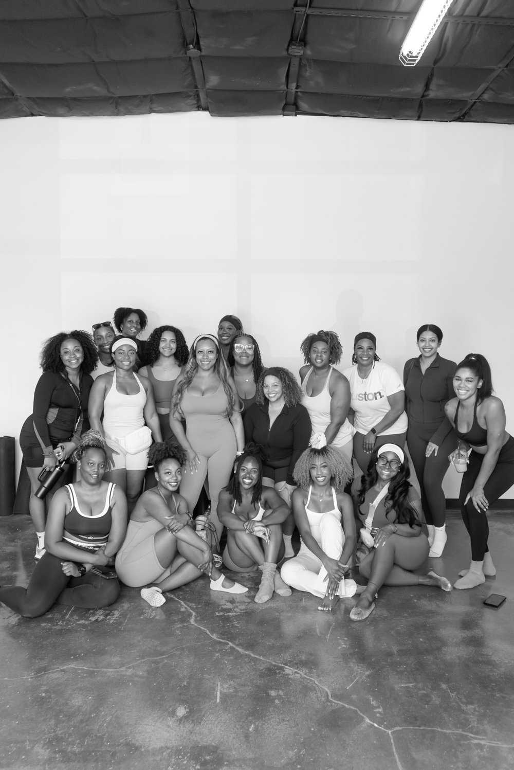 Large group of community members posing together after a pilates class