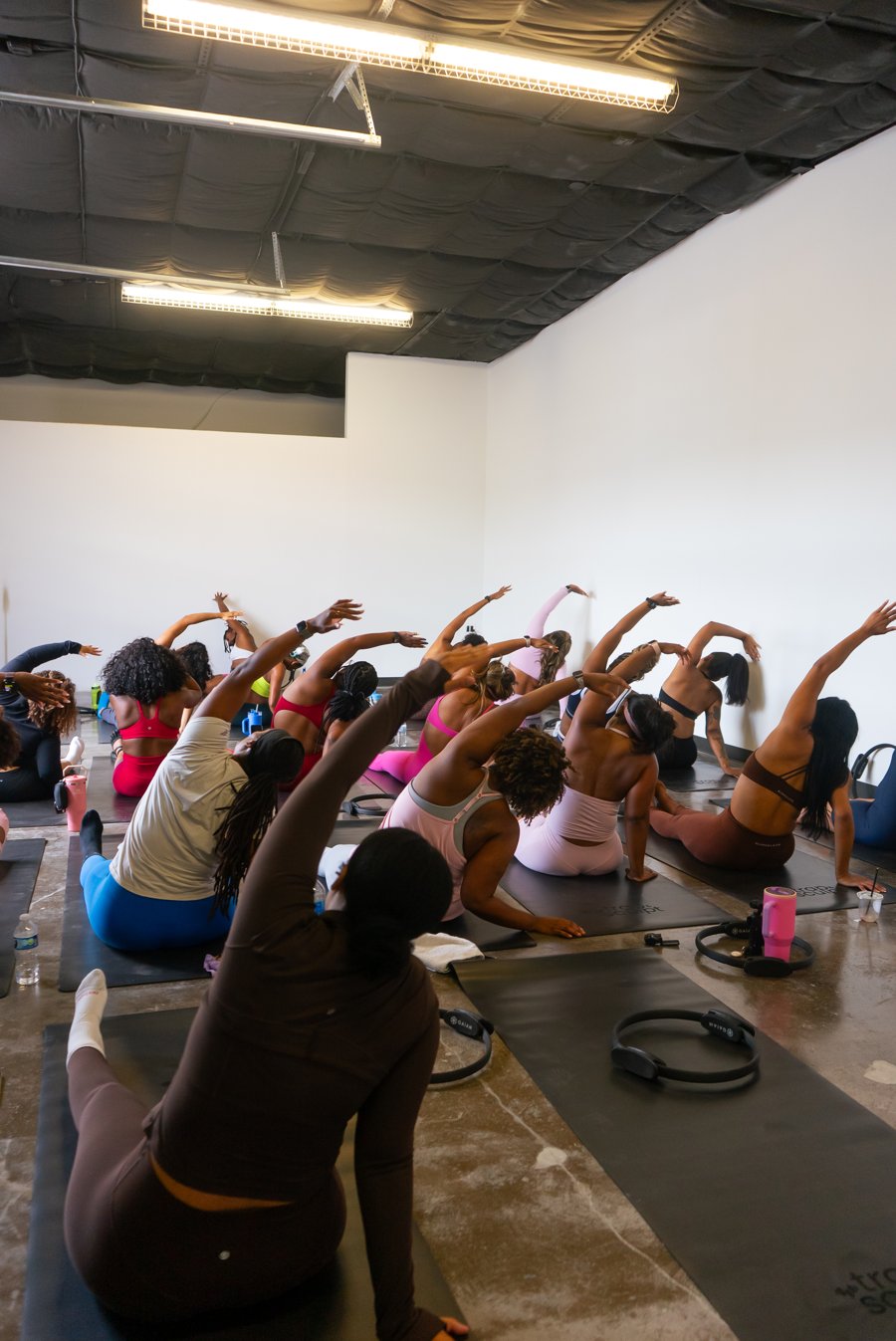 Full pilates class stretching on mats in a studio
