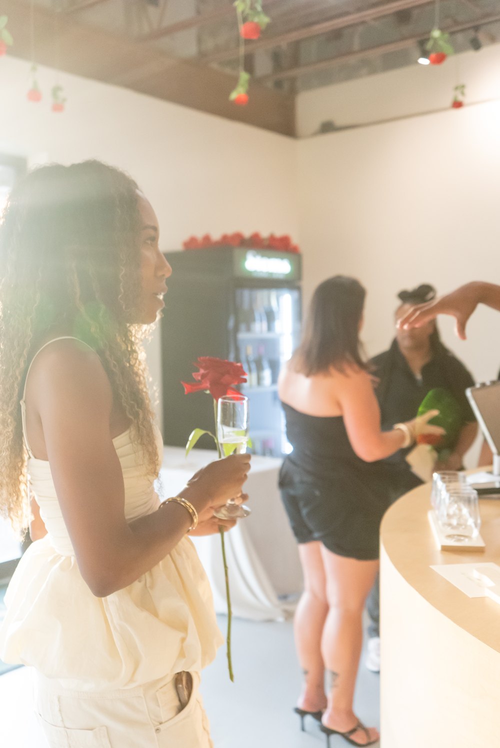 Guest holding a rose and a glass of sparkling wine at a wine tasting night