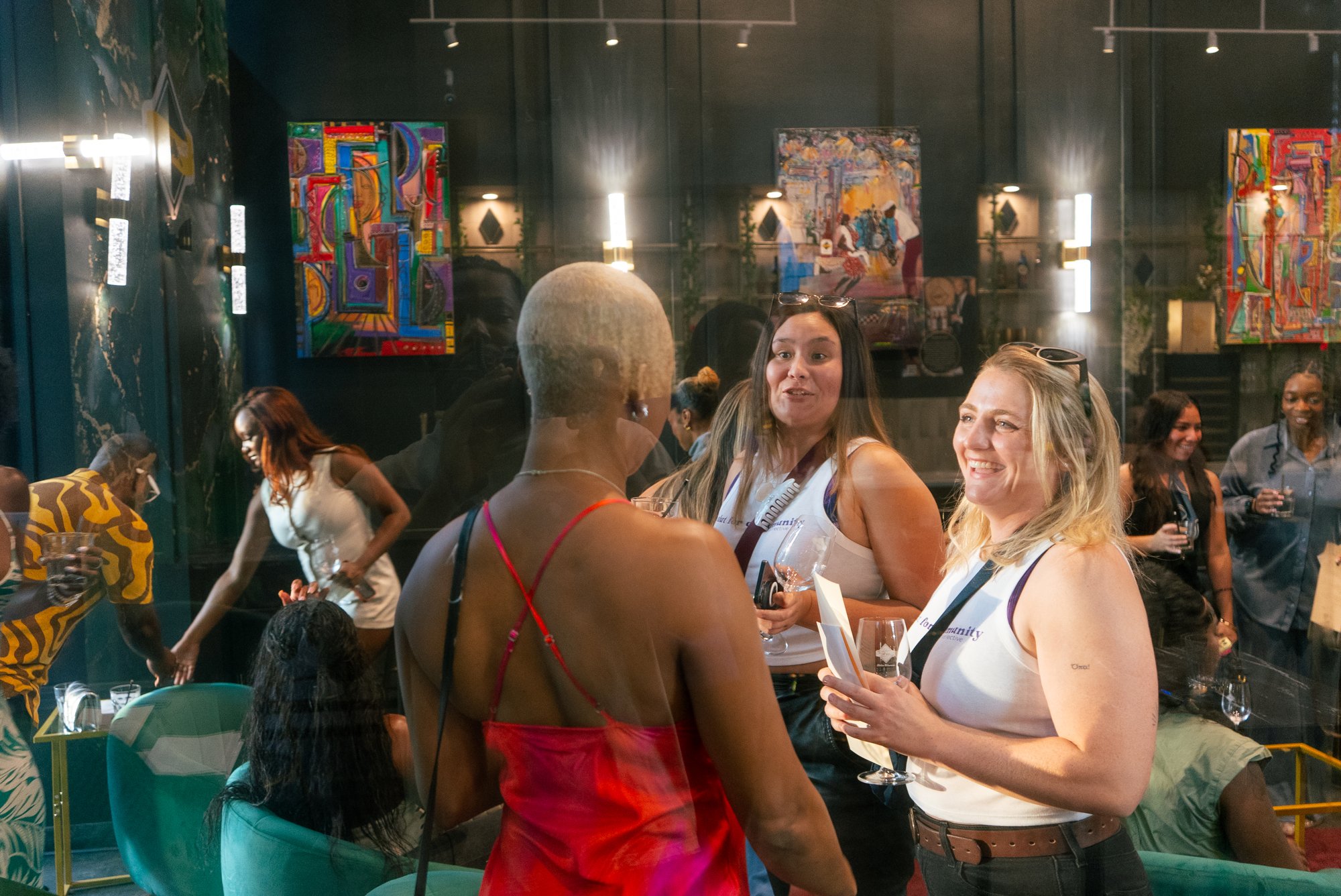 Community members laughing and talking over wine at a Locals experience inside a partner venue