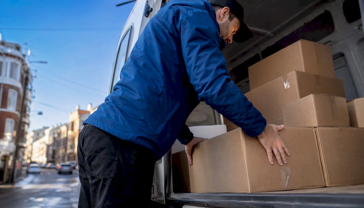 Courier loading packages into delivery van