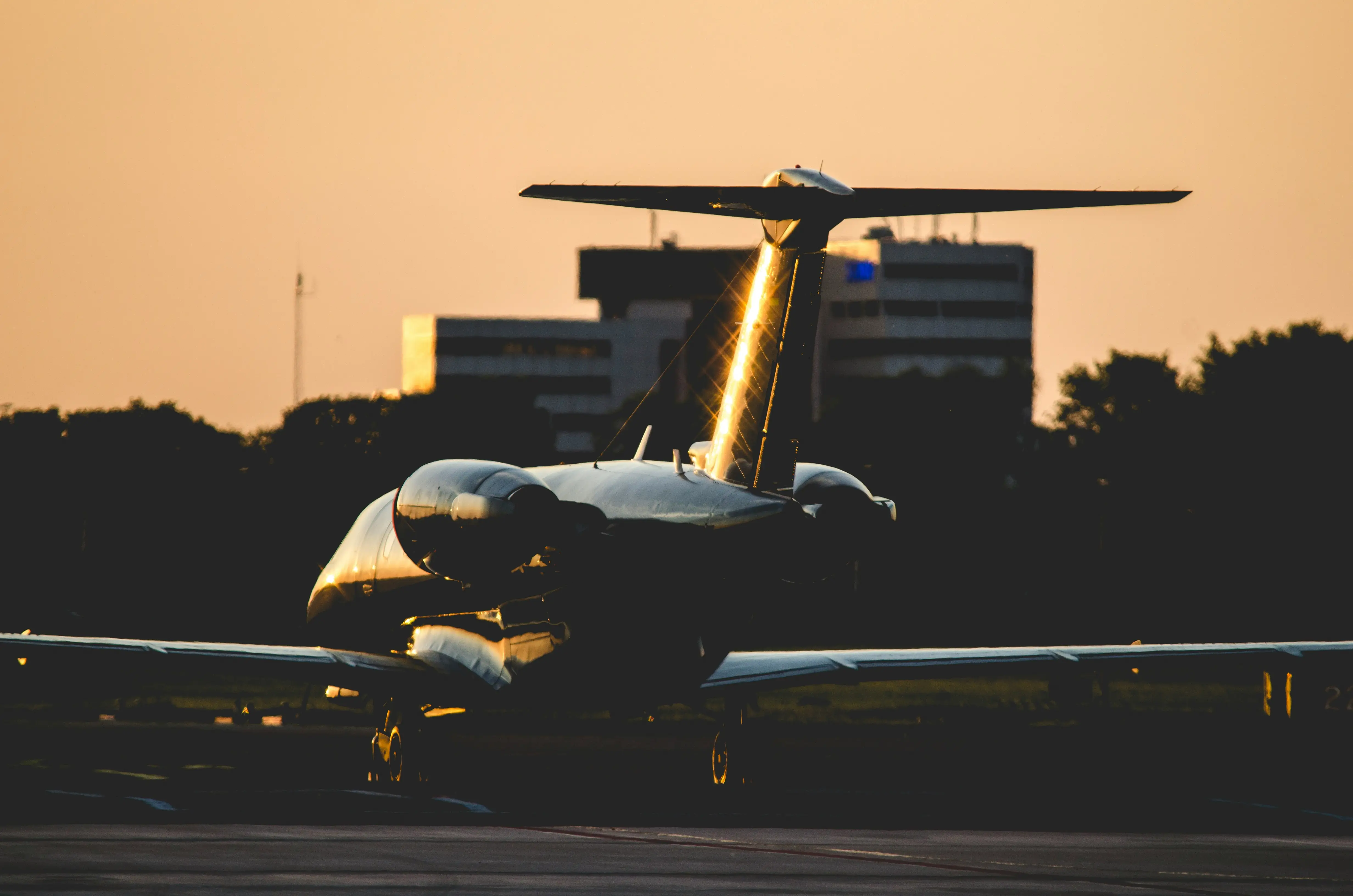 Aircraft on runway at sunset with golden light reflecting off its surface