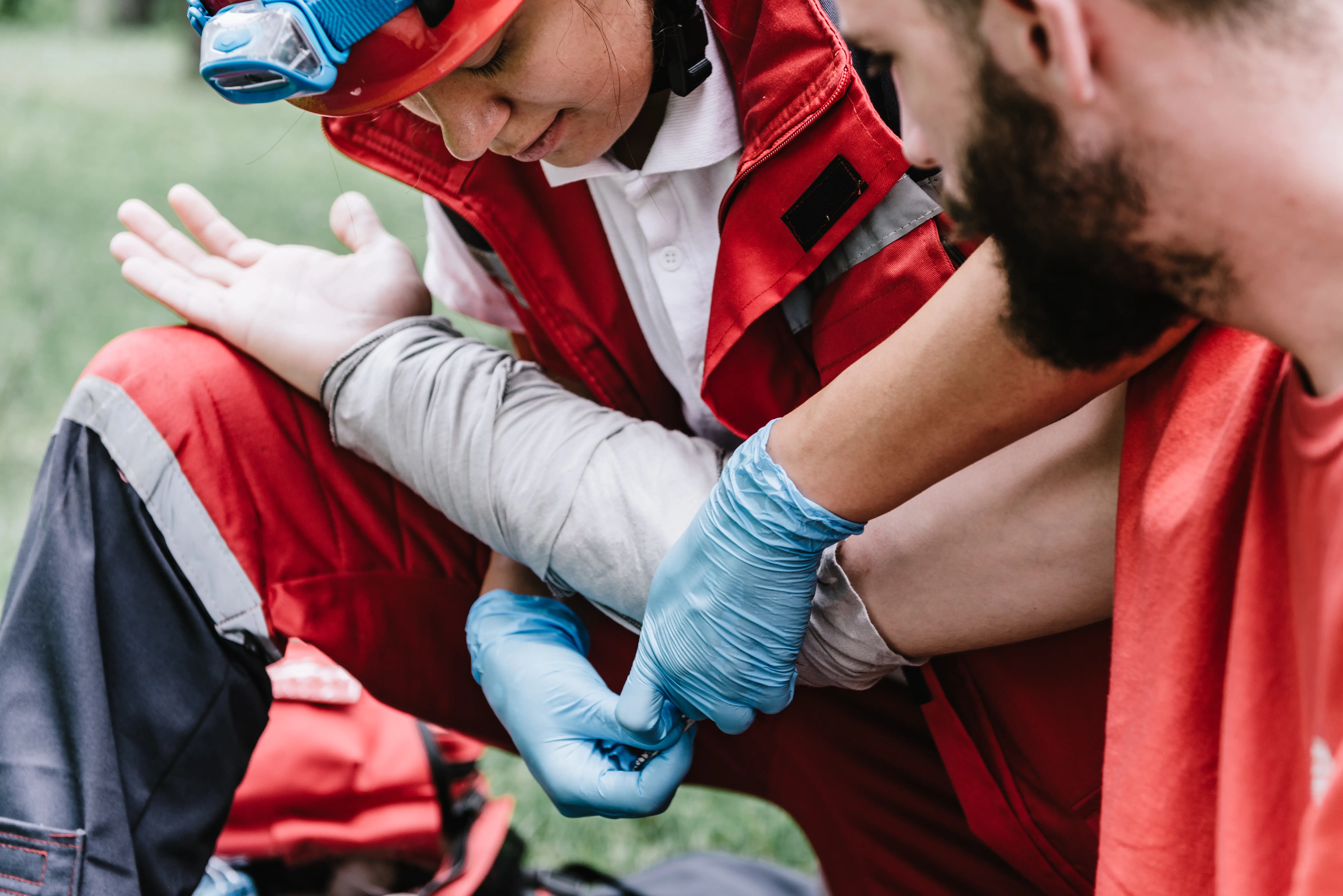 First aid responder treating an injury with blue medical gloves
