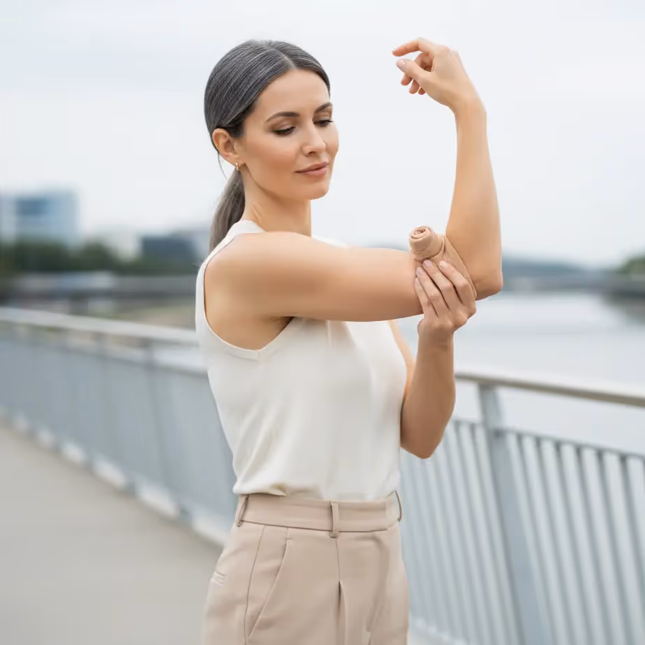 Brahioplastika ali liposukcija nadlahti? Nežen fokus na zadnji strani nadlahti in diskreten kompresijski rokav za jasnejšo odločitev.