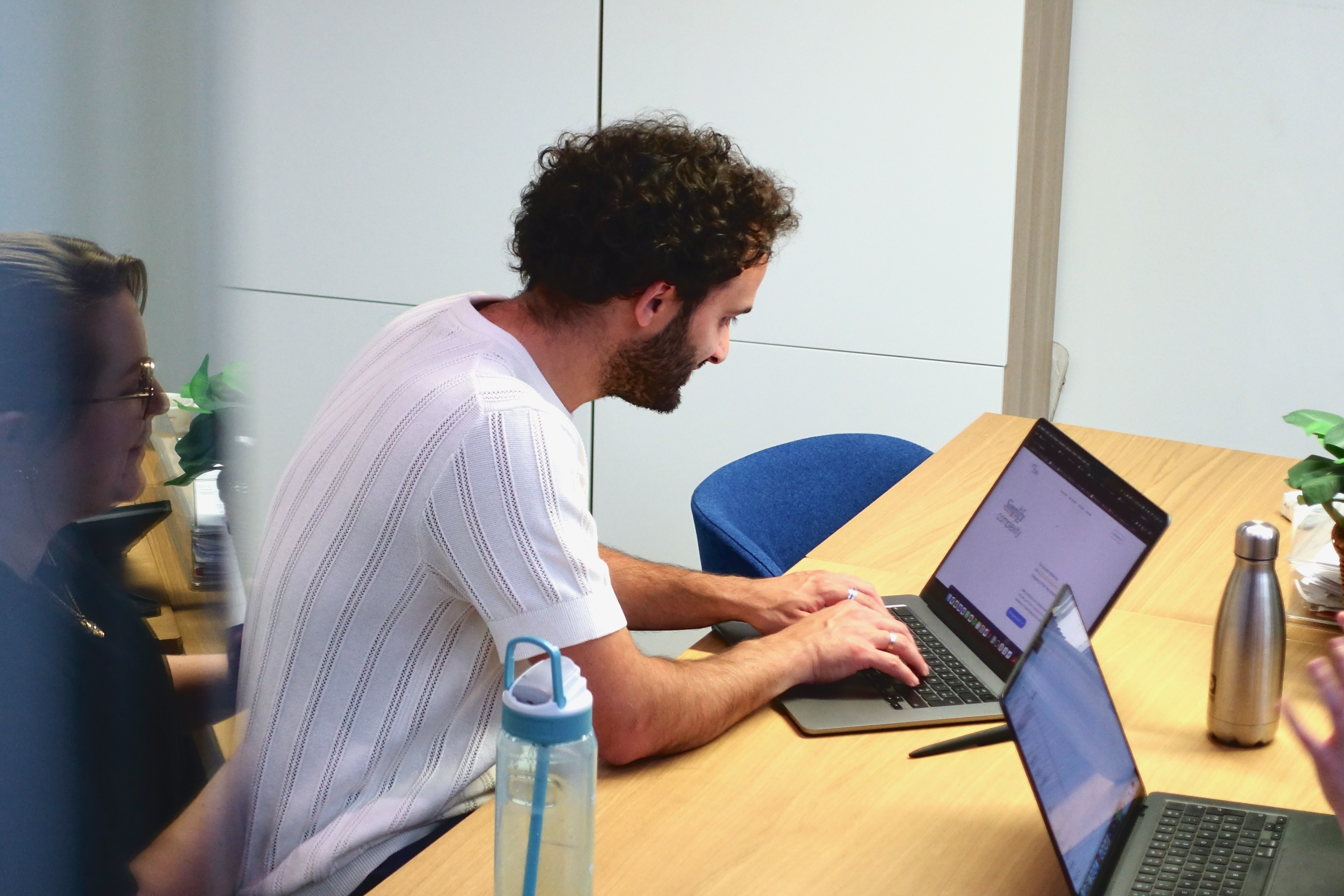 Bernard en Charlotte van Umbau bespreken een B2B-marketingstrategie achter hun laptop, gefocust op het vertalen van complexe communicatie naar heldere resultaten.