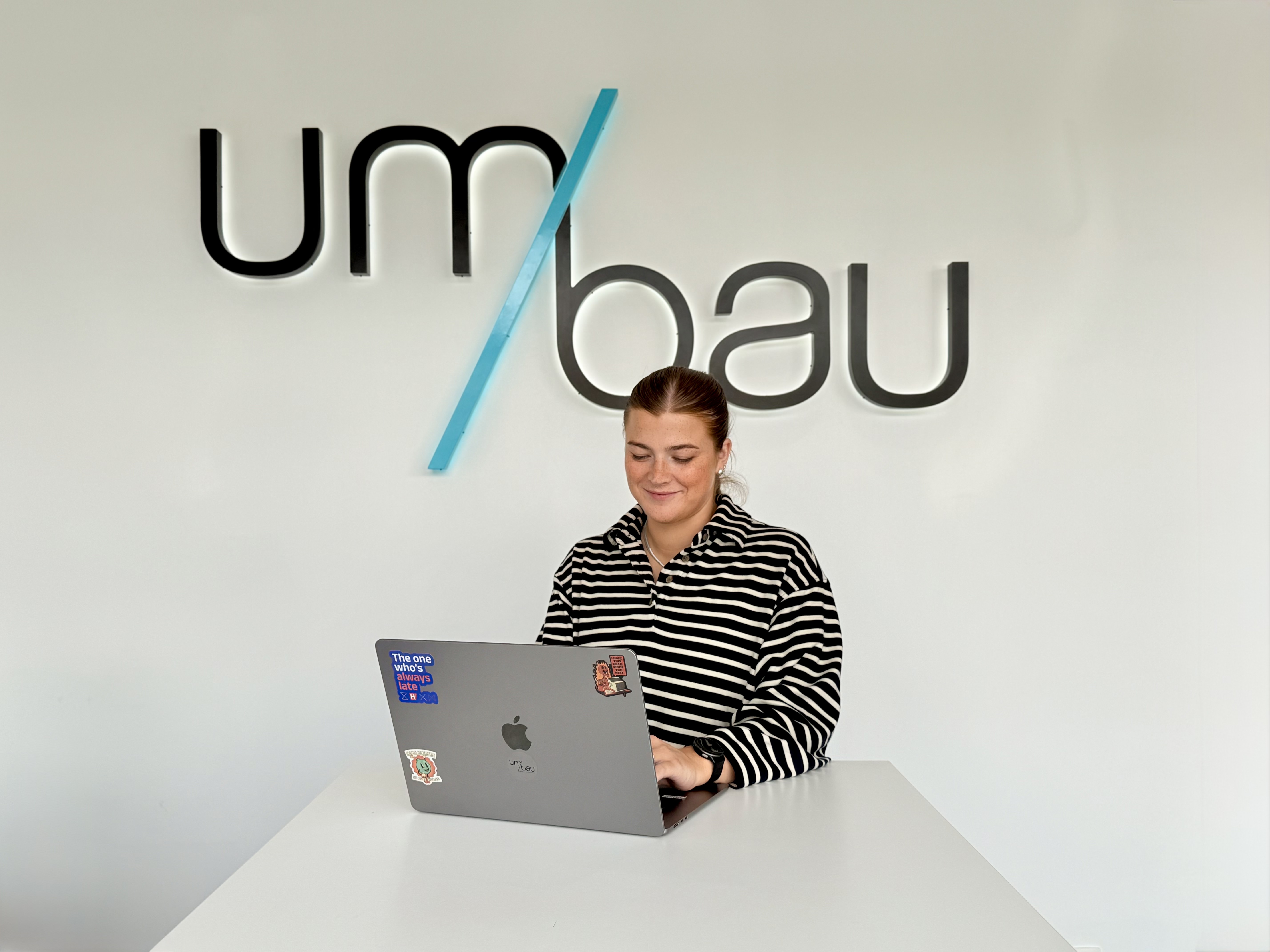 Yente werkt gefocust aan een strategiepresentatie, met het Umbau-logo subtiel op de achtergrond