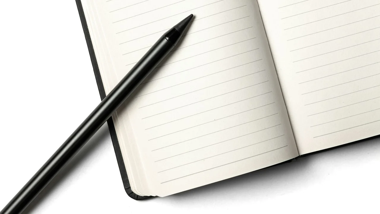 Zwarte pen op een open gelijnd notitieboek