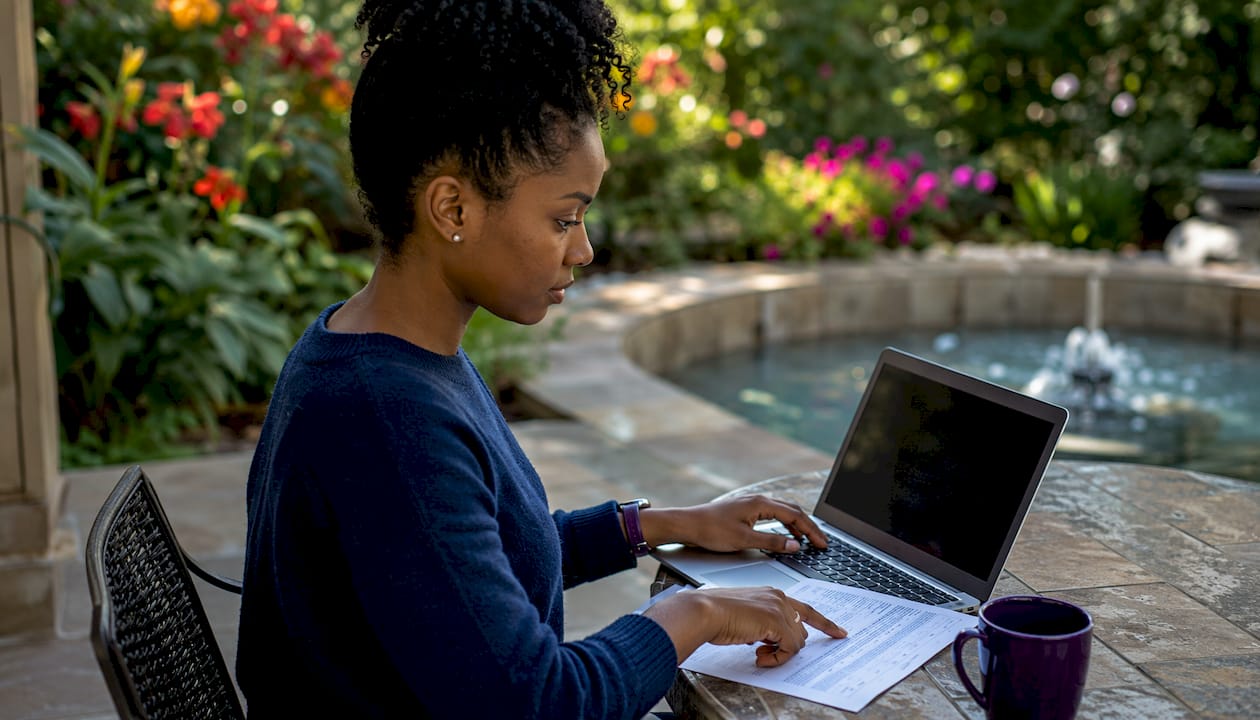 Woman entering K-1 data into Form 1040 on laptop