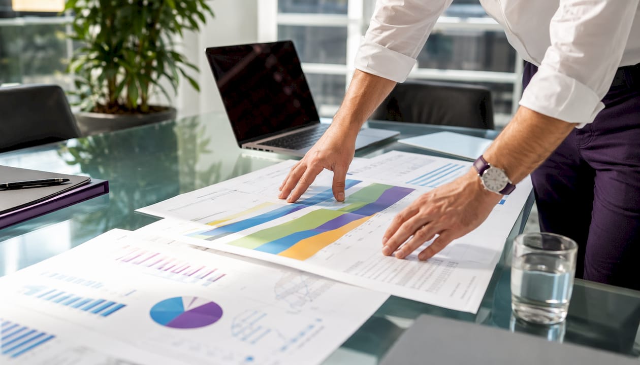 Hands reviewing energy production modeling sheets