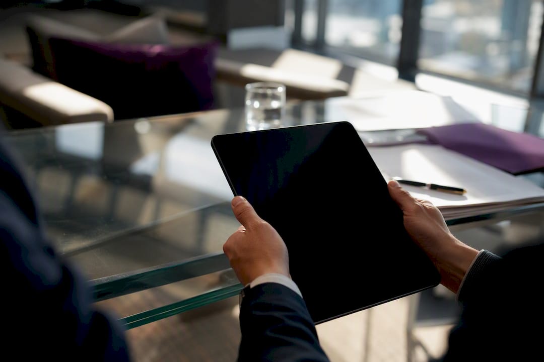 Investor hands holding tablet in office setting