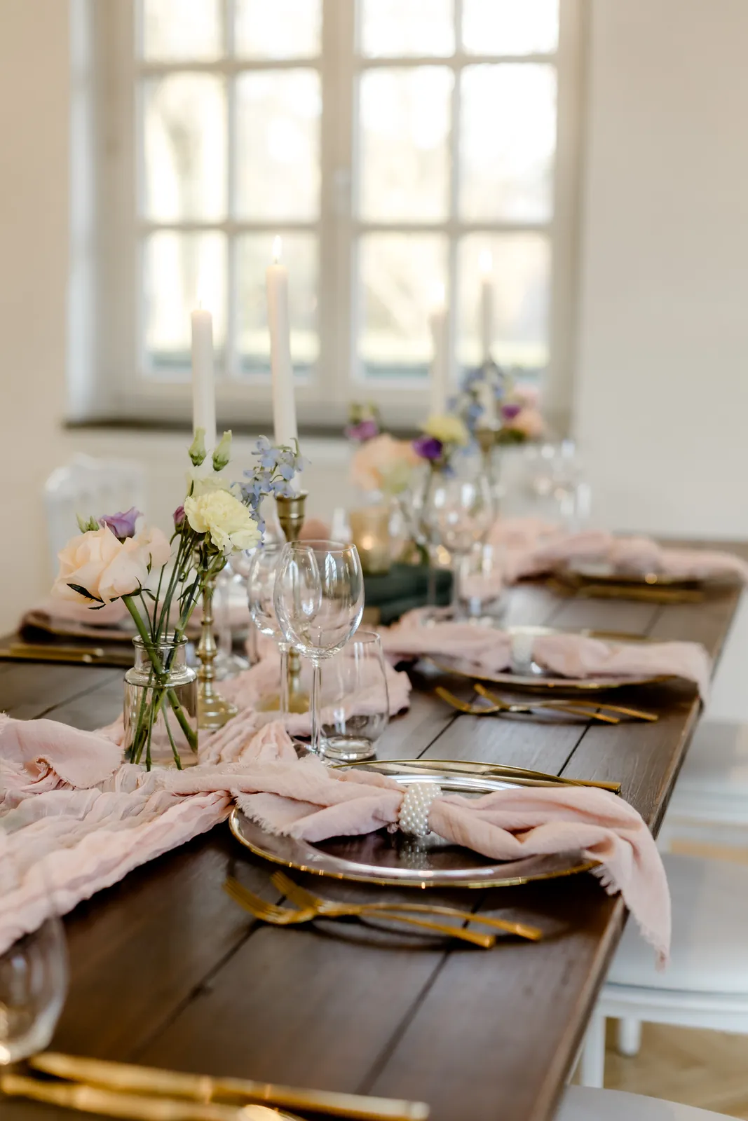 Hochzeitstafel von PURE FLAIR mit altrosa Tischläufer, Goldbesteck und zarter Frühlingsfloristik