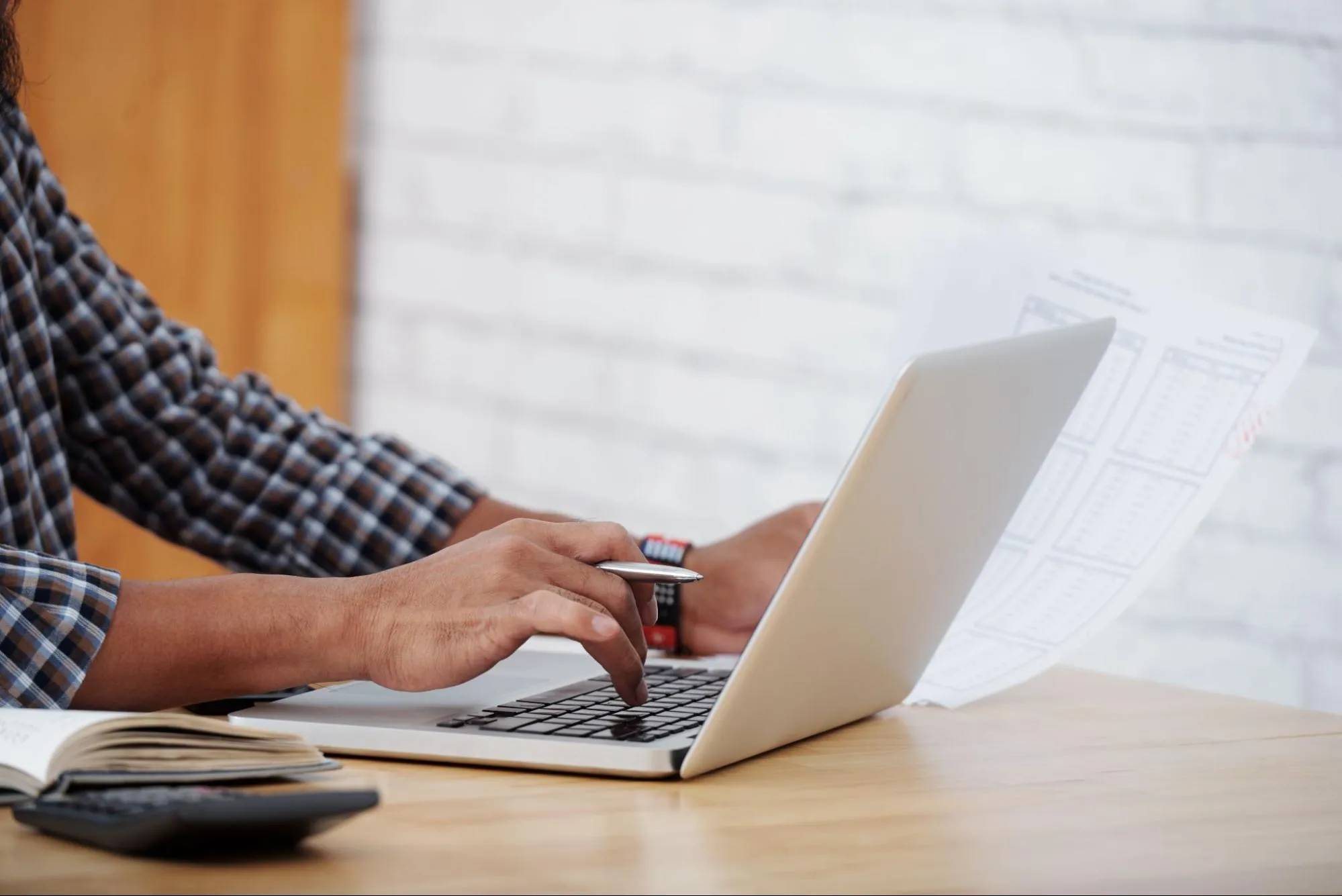 main d’homme tapant sur un ordinateur pour obtenir son devis en ligne transport