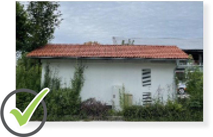 Kleines Gebäude mit intaktem roten Dach.