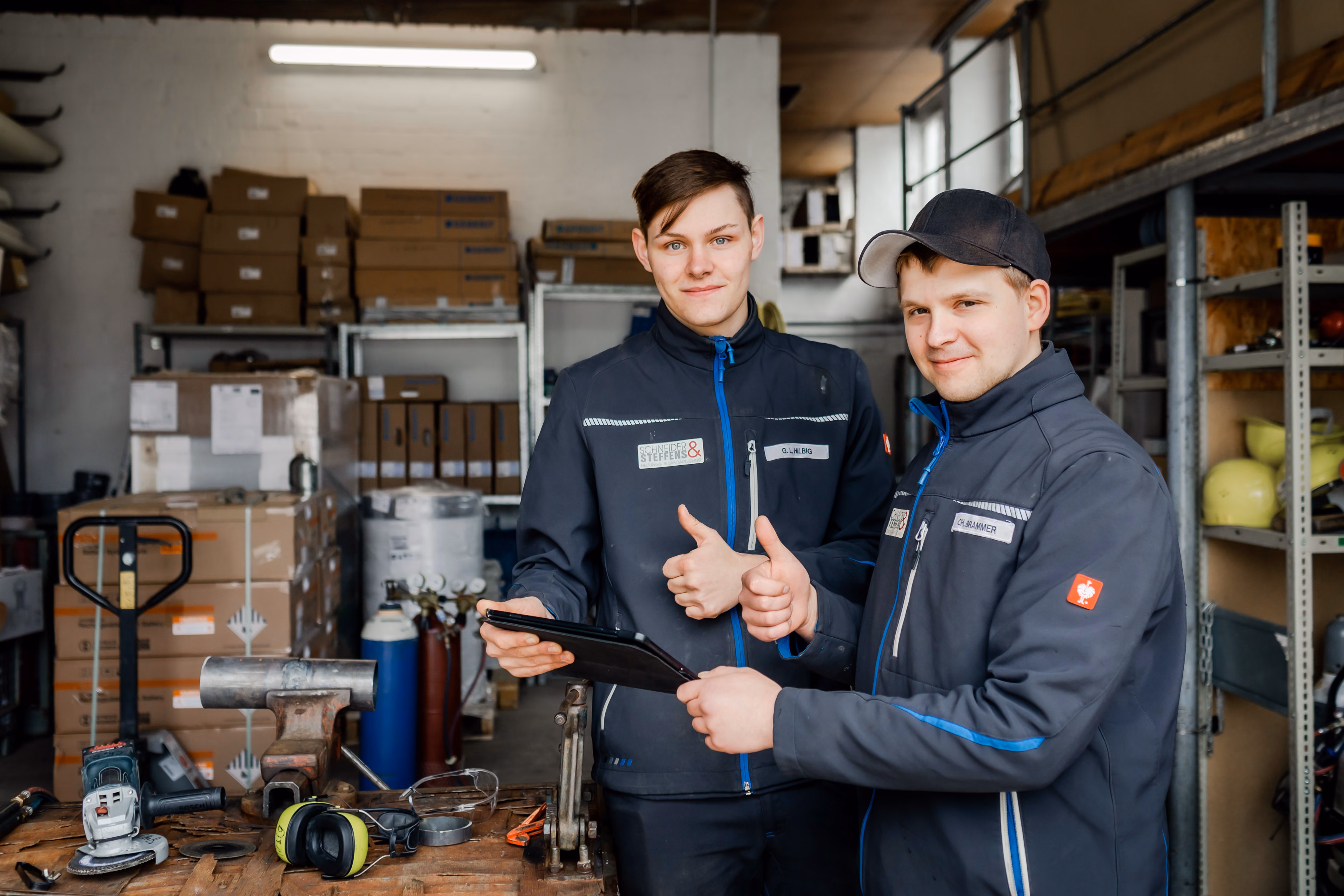 Zwei Mitarbeitende arbeiten gemeinsam mit einem Tablet in der Werkstatt.
