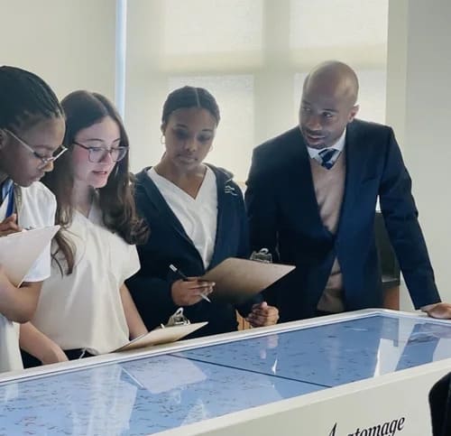 Students and teacher examining an interactive touchscreen table together