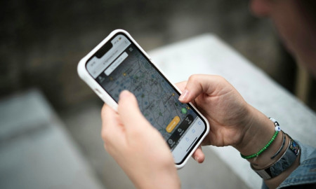 A female's hands holding a smartphone with a navigation app displayed on the screen