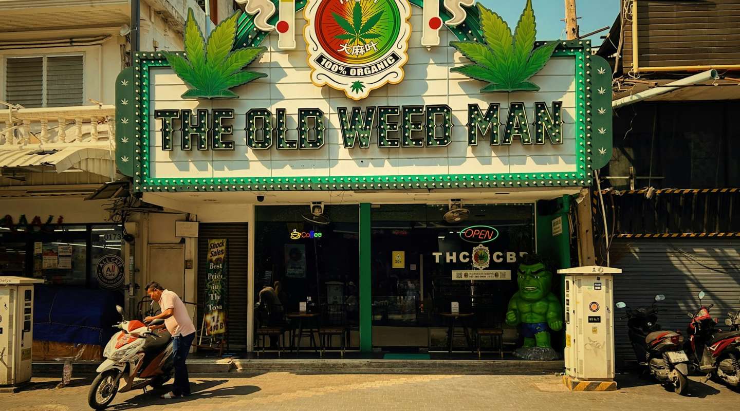 Exterior of The Old Man Weed Store in Thailand with a man tending to his moped