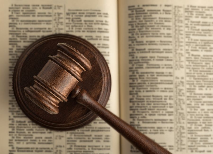 A wooden judge's gavel resting on an open law book