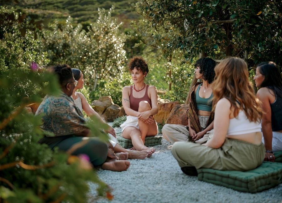 Small group sitting in a circle outdoors during a guided retreat discussion