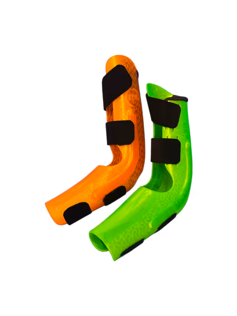 Deux attelles orthopédiques, une orange et une verte, avec des sangles noires réglables.