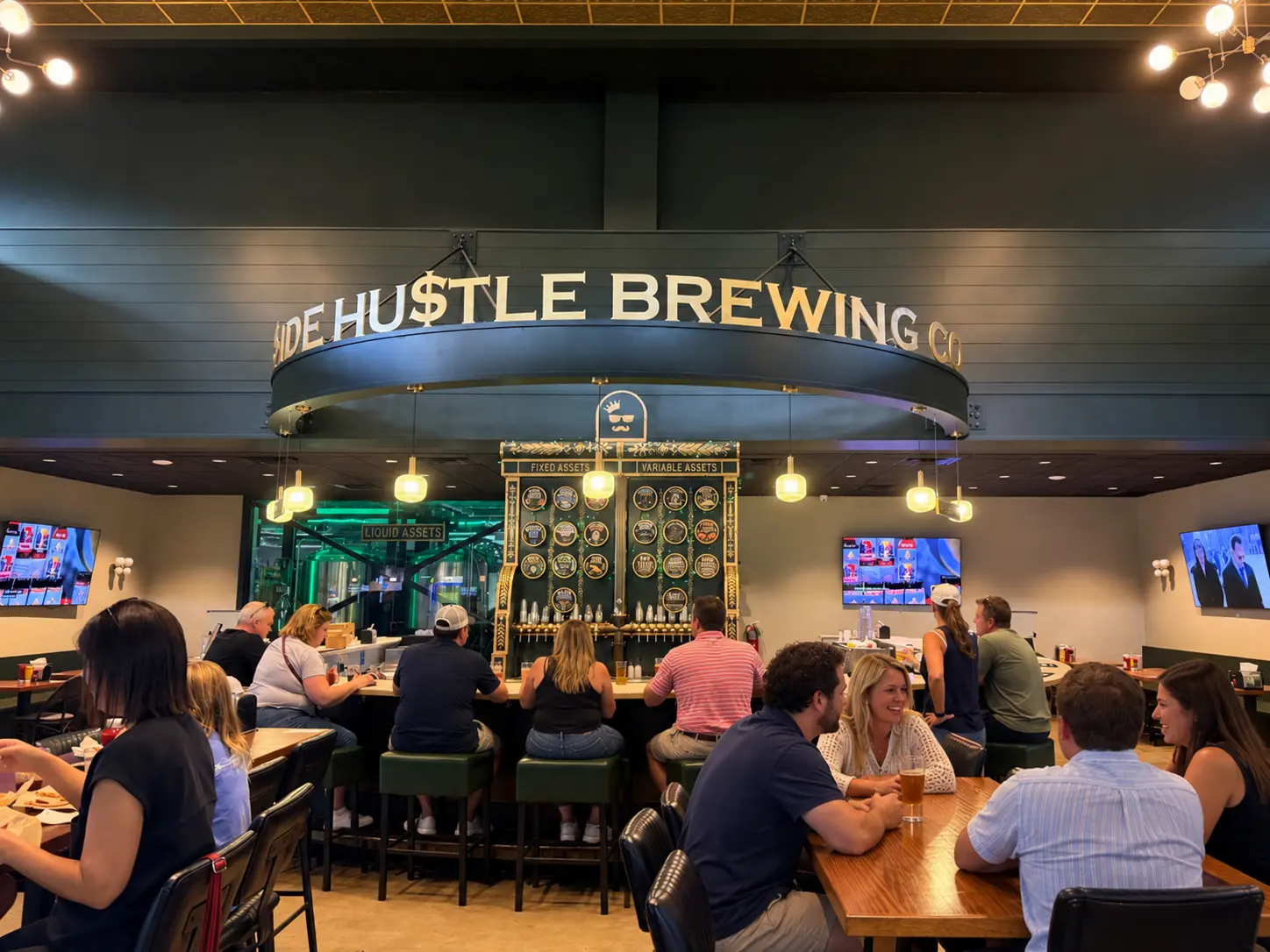 Modern bar with curved counter, green stools, wooden tables, and signage for withdrawals, deposits, beer garden.
