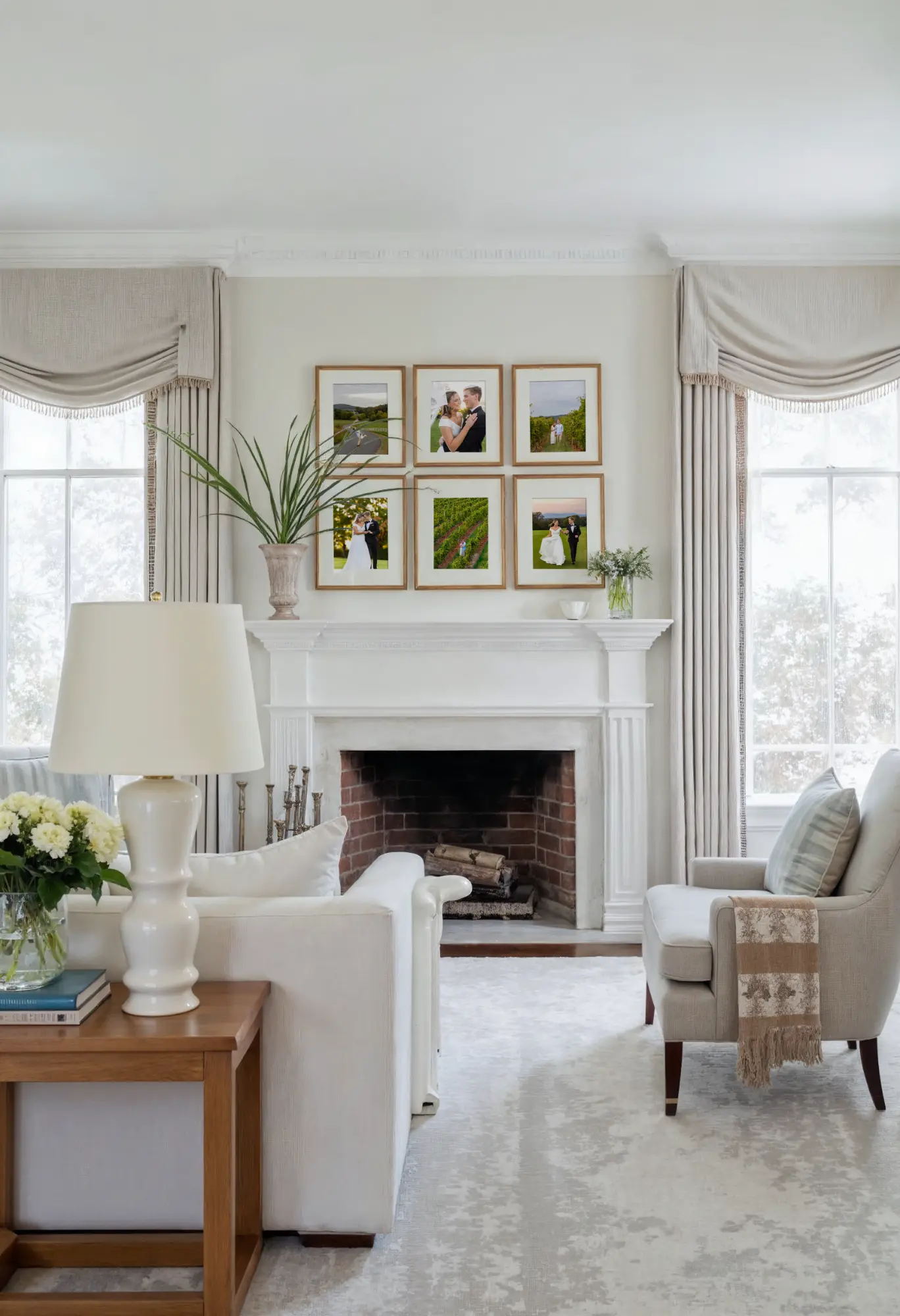 A living room with a white fireplace, framed photos, and a potted plant on the mantel.