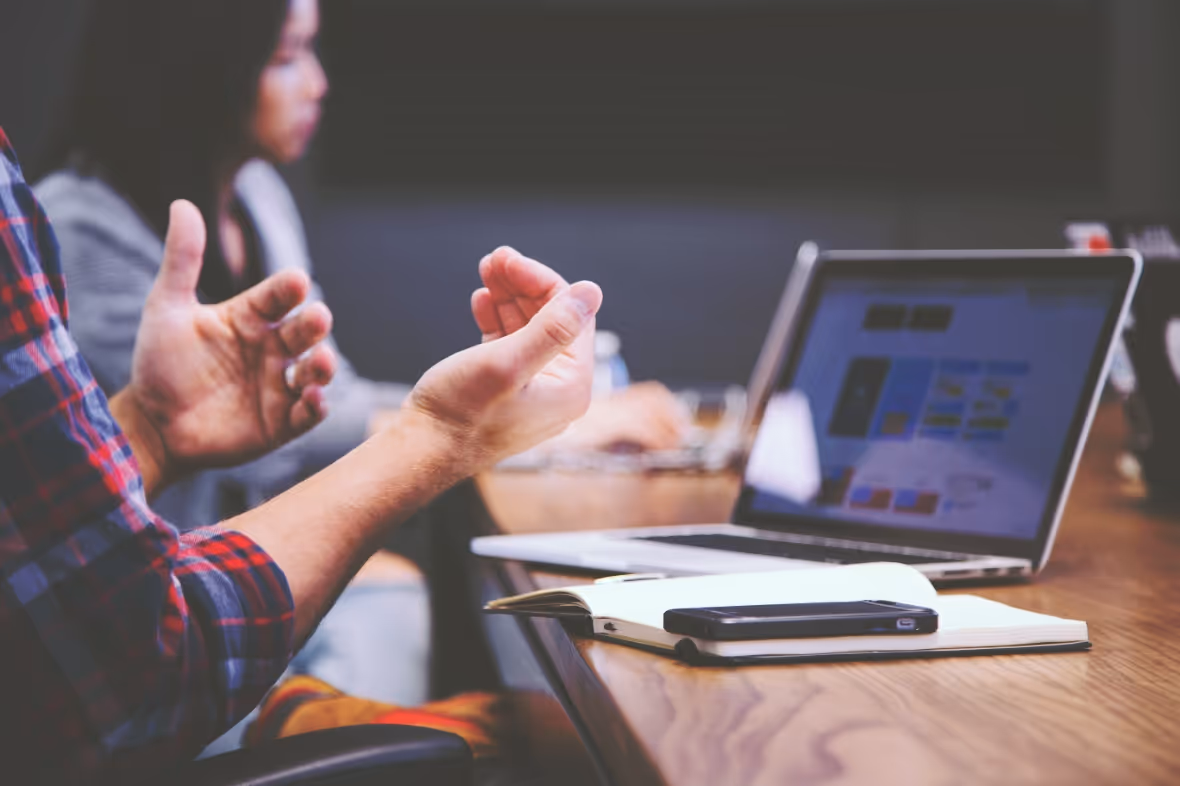 Man speaks with his hands in a team meeting.
