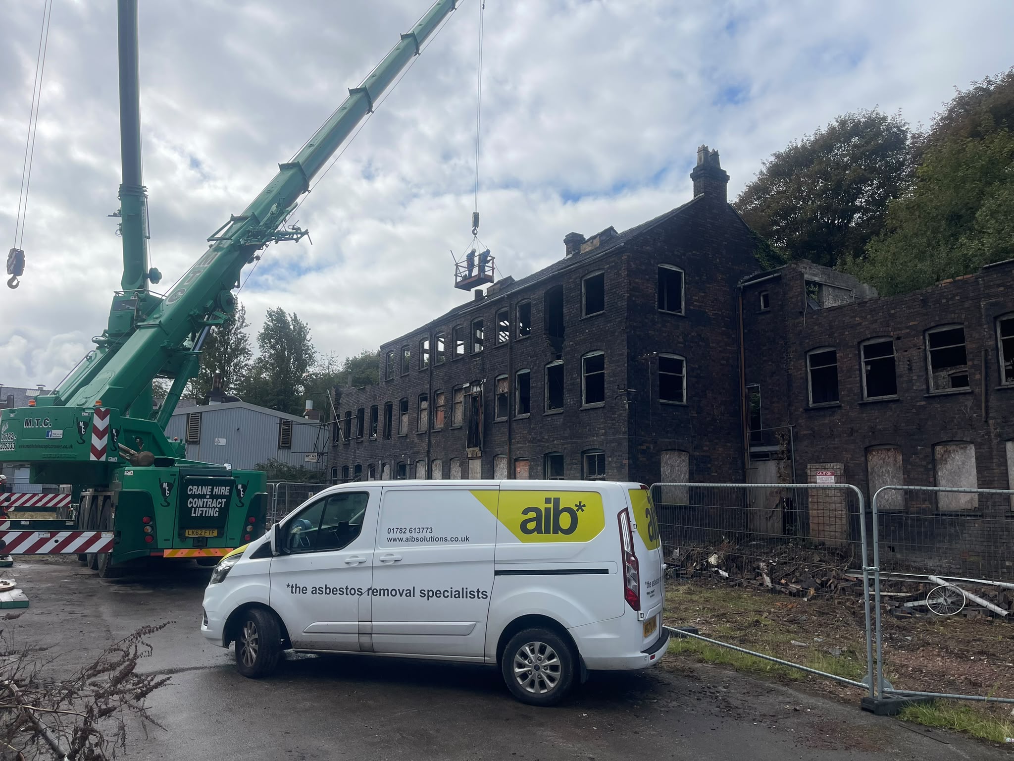 AIB Solutions van and contract lifting crane on site at the fire-damaged Falcon Works, Stoke-on-Trent