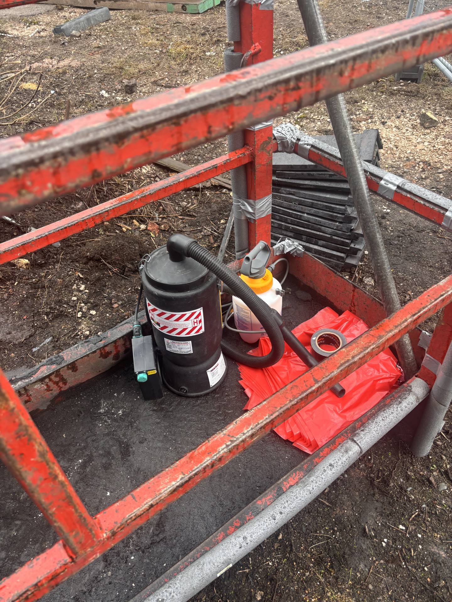 Battery-powered H-class vacuum and red asbestos waste sacks inside the man basket