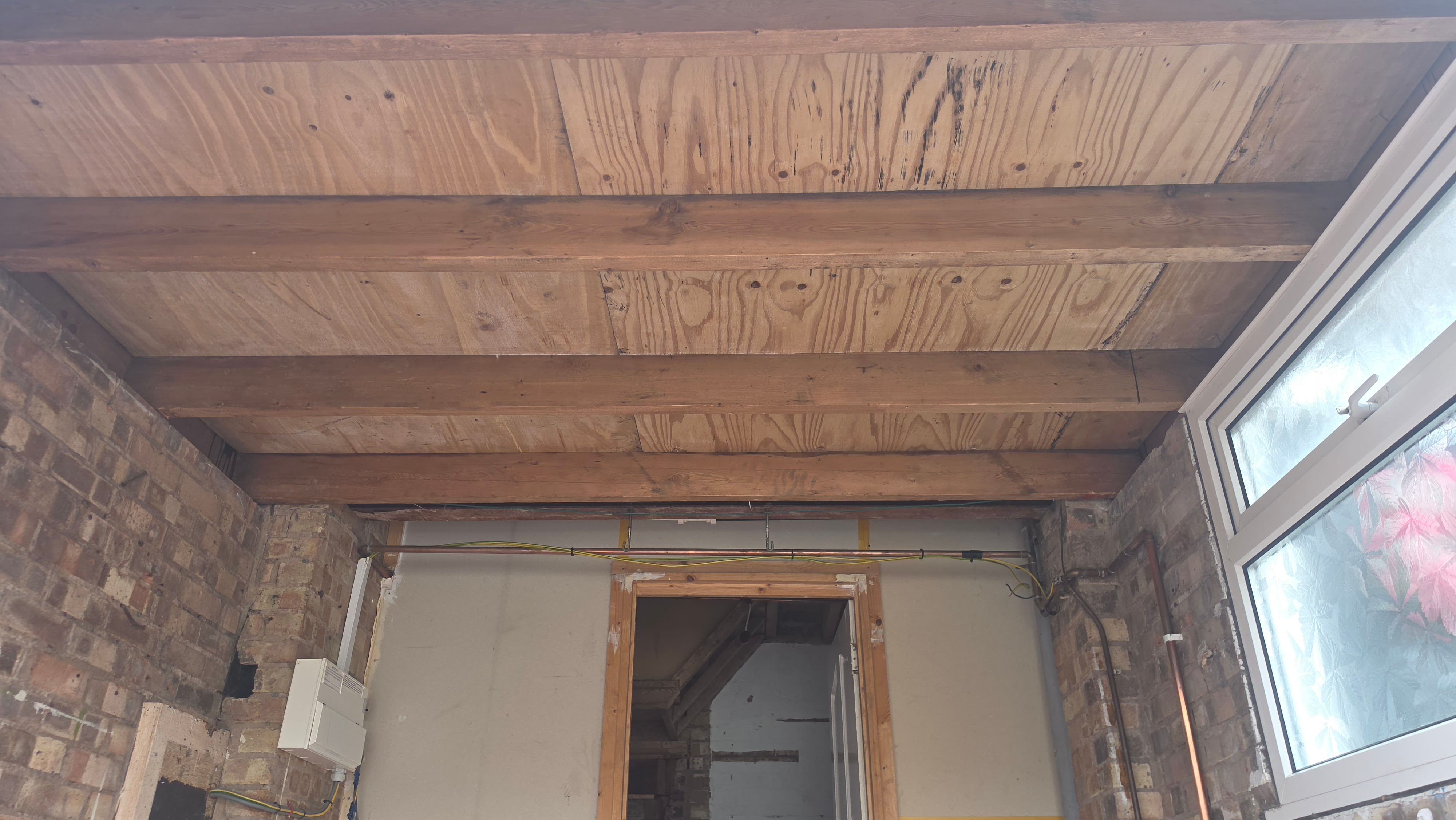 Garage ceiling after AIB removal, joists exposed and clean