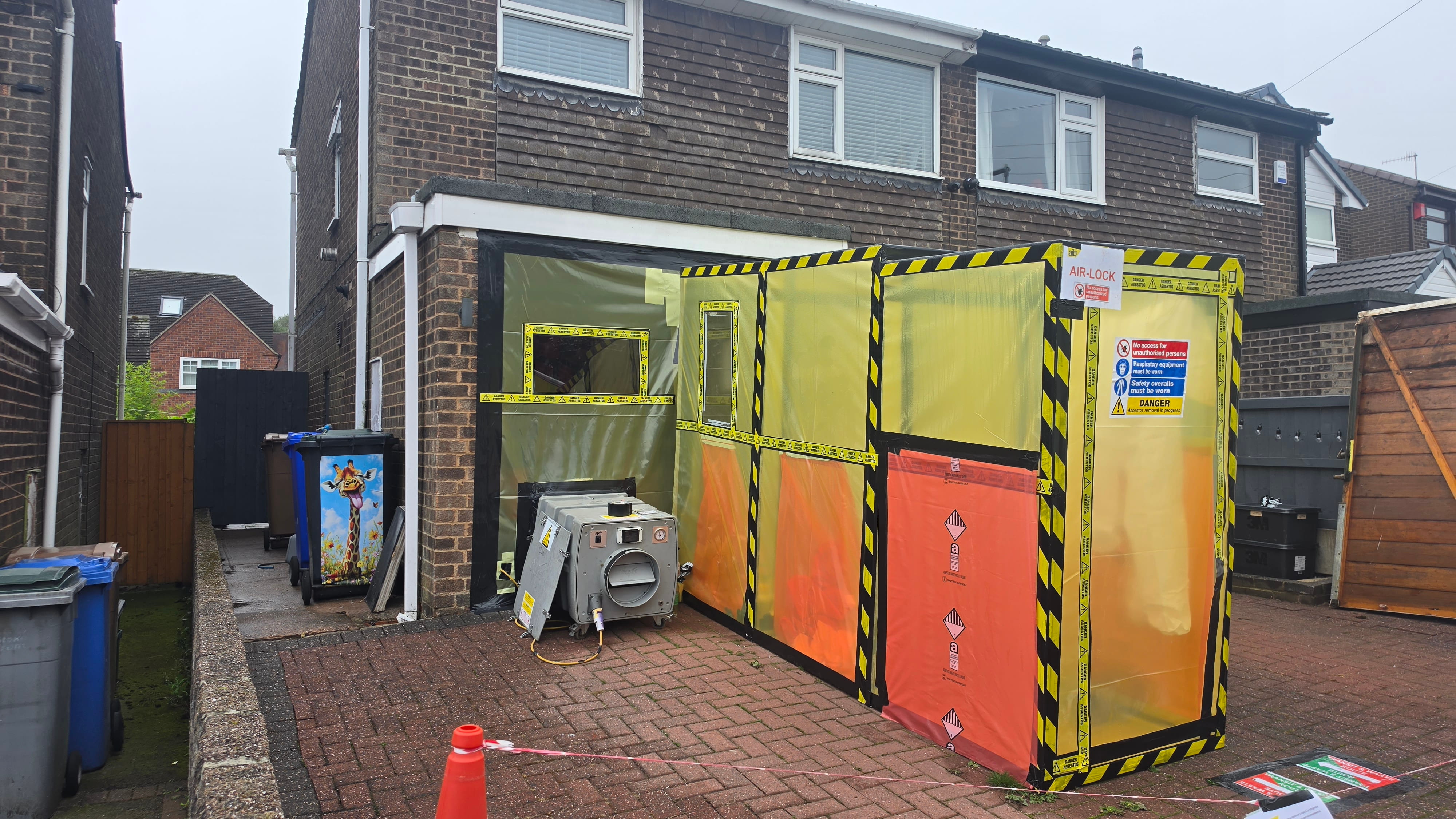 Sealed asbestos enclosure and airlock built across a domestic garage frontage