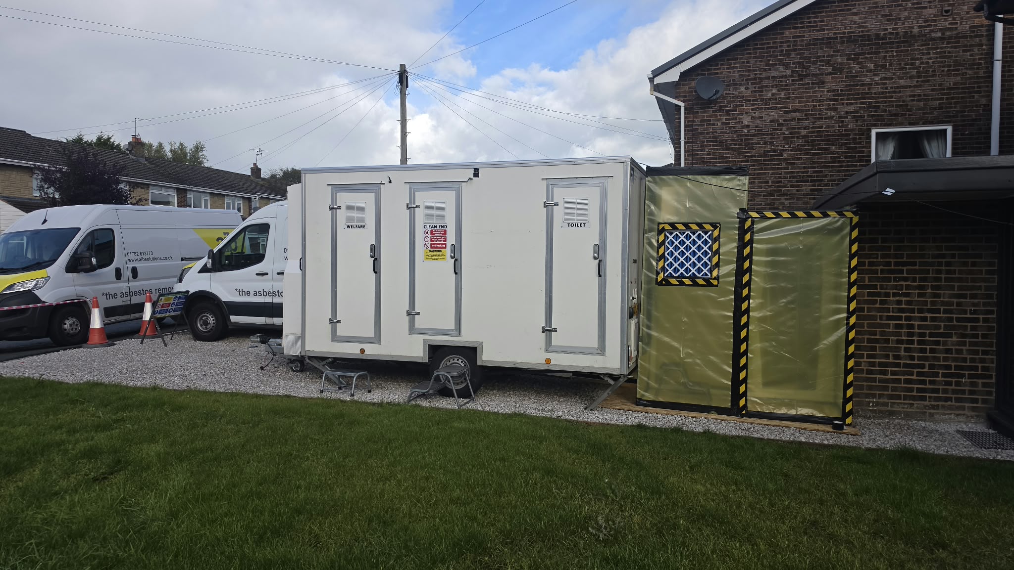 Decontamination unit connected directly to the asbestos enclosure on the driveway of a house in Wales