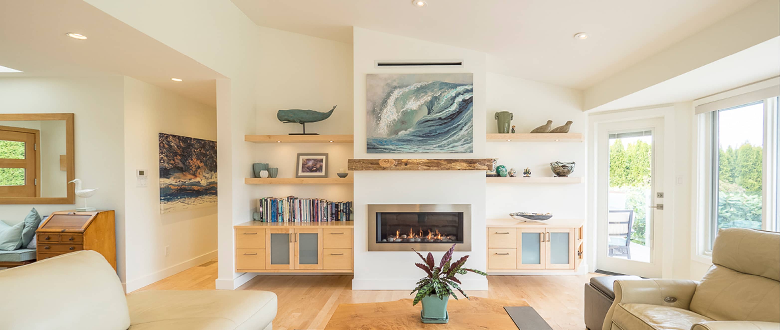 Bright and spacious residential living room with a custom fireplace, built-in shelving, and west coast-inspired decor. Delivered by Outlook Project Management as part of their residential construction services in Victoria, BC.