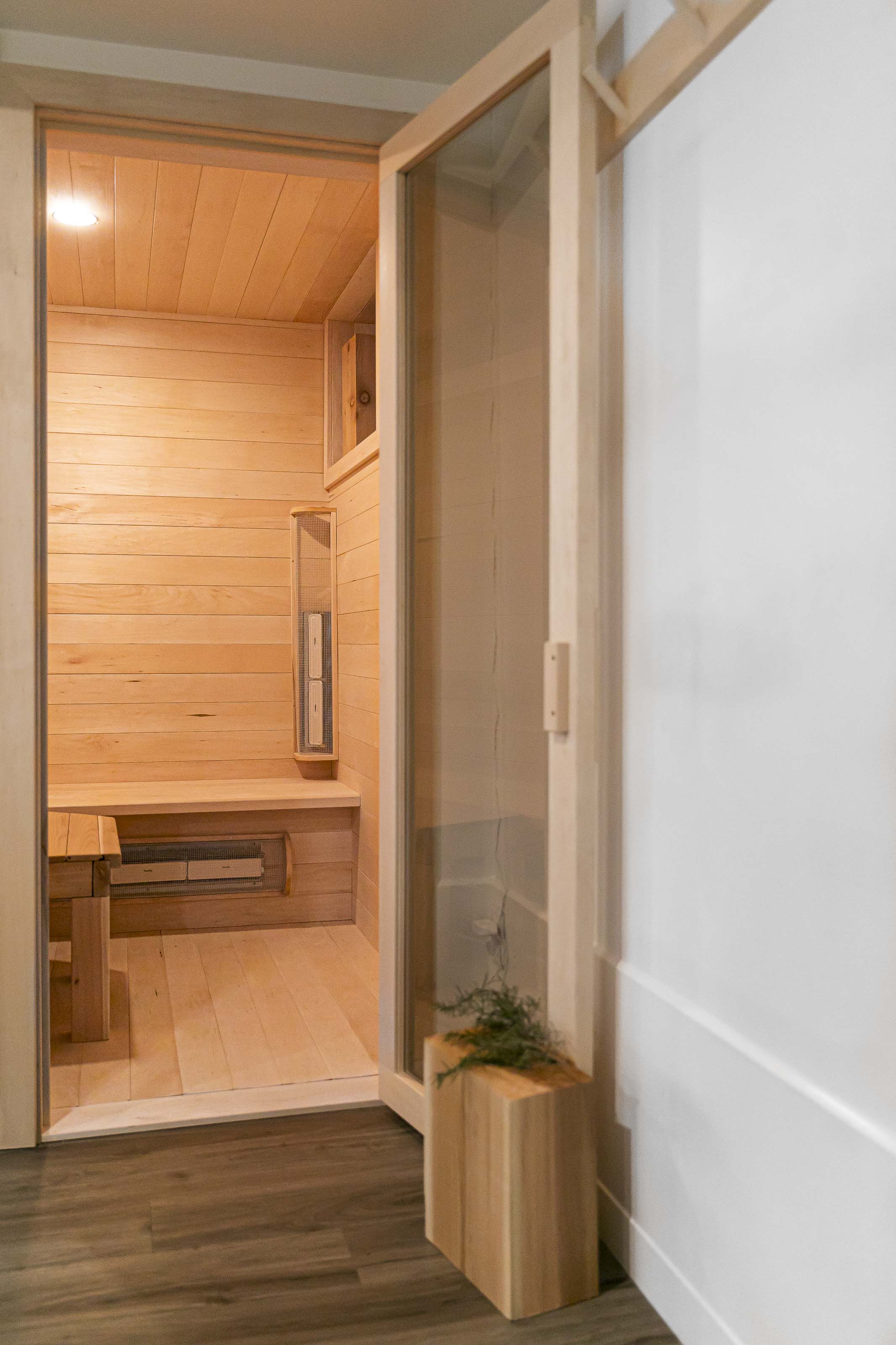 Close-up of custom black timber brackets and classic glass lantern sconces mounted above a wooden garage door at a residential home in Victoria, BC, by Outlook Project Management.