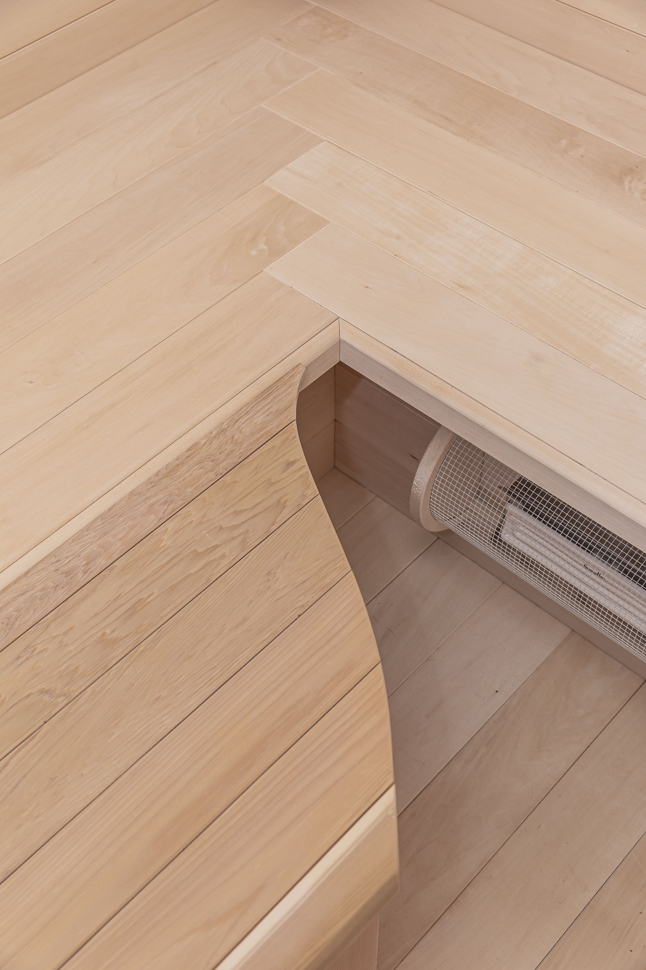 Detail of precision-cut wood bench corner and clean joinery work in a custom-built sauna interior, showcasing fine craftsmanship by Outlook Project Management.