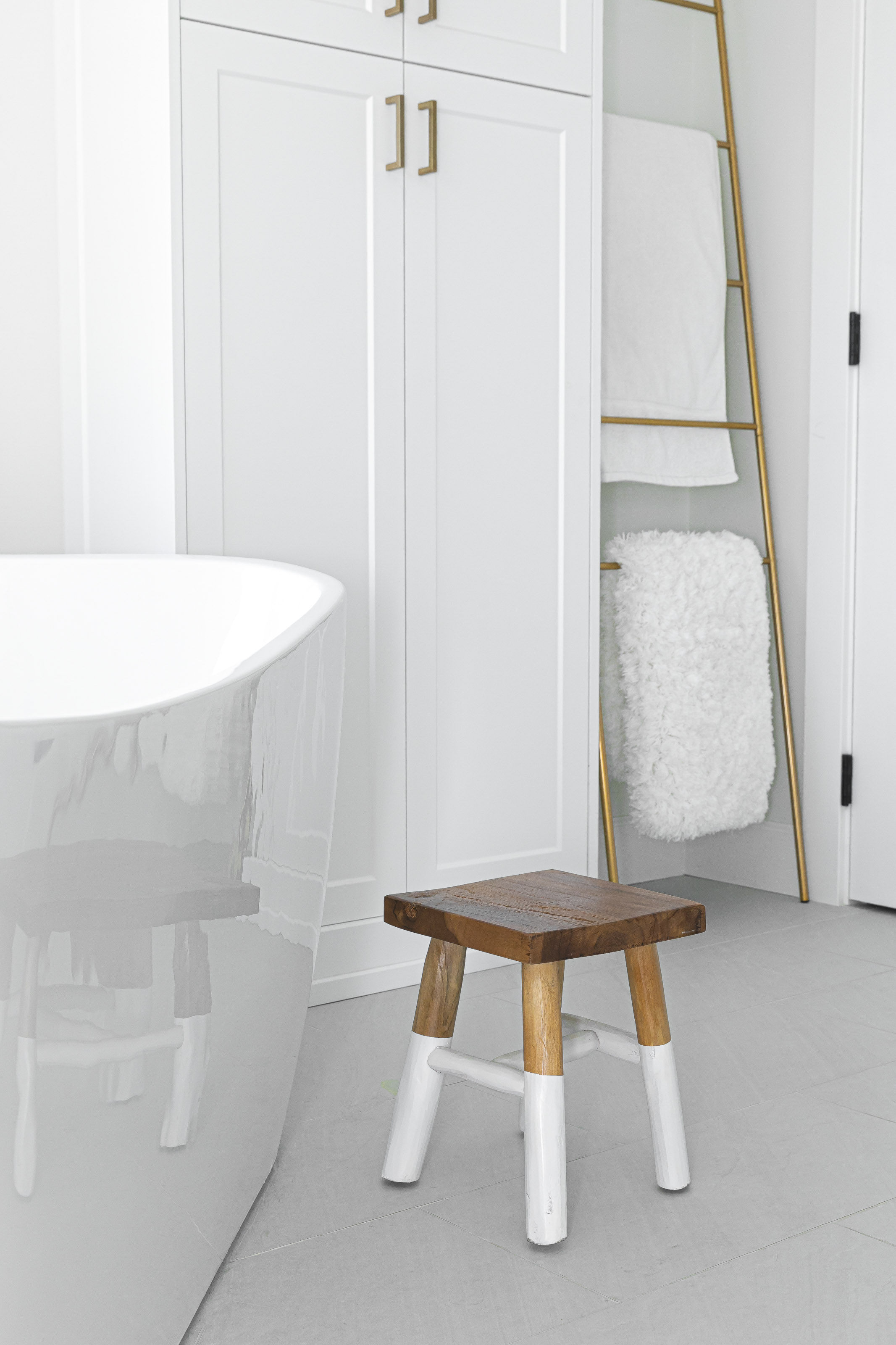 Bright bathroom with modern white cabinetry, freestanding tub, and warm wood accents, renovated in Victoria, BC.