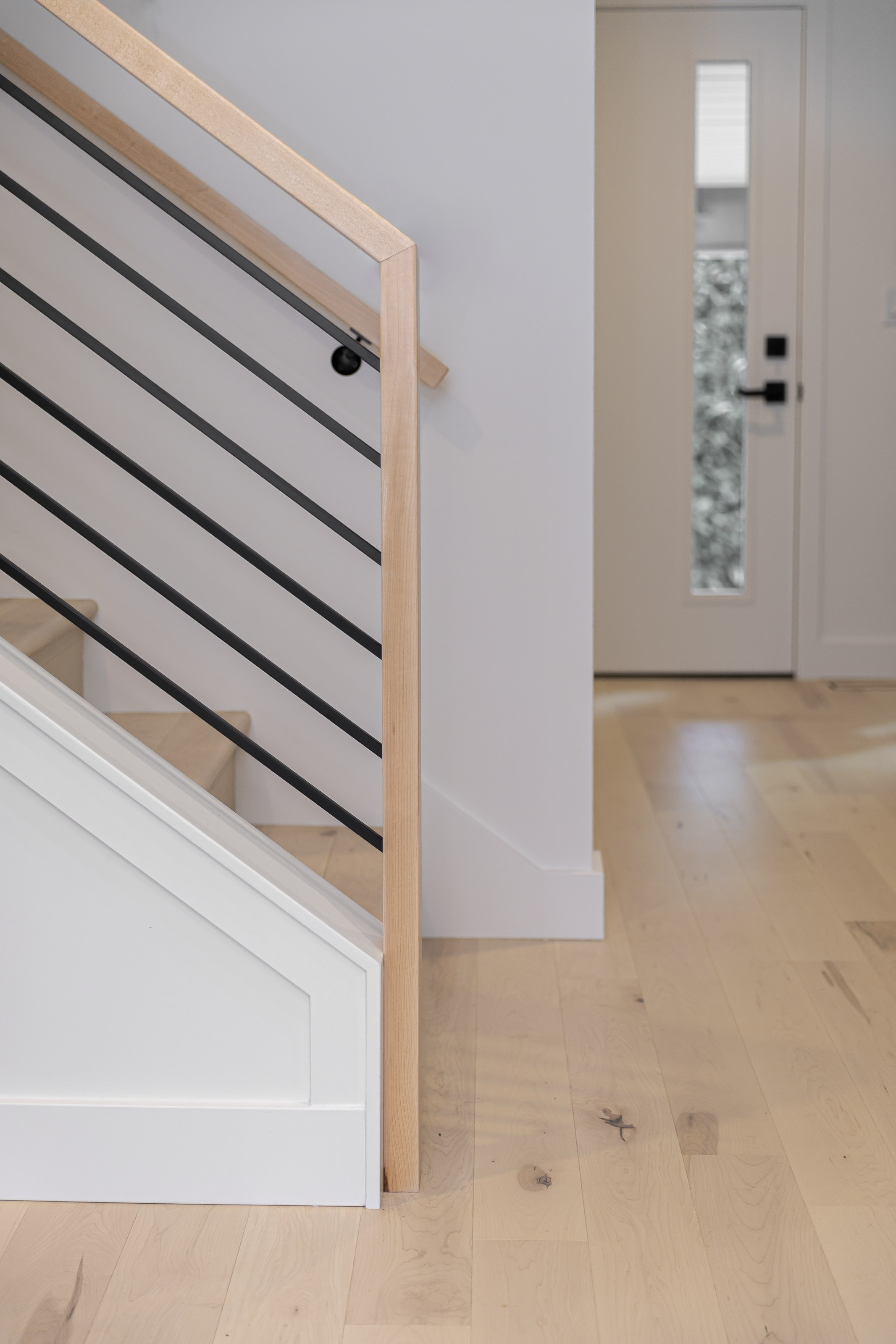Full view of the remodeled kitchen in the Warder project by Outlook Project Management, featuring black cabinetry, stainless steel appliances, and white quartz countertops in Victoria BC