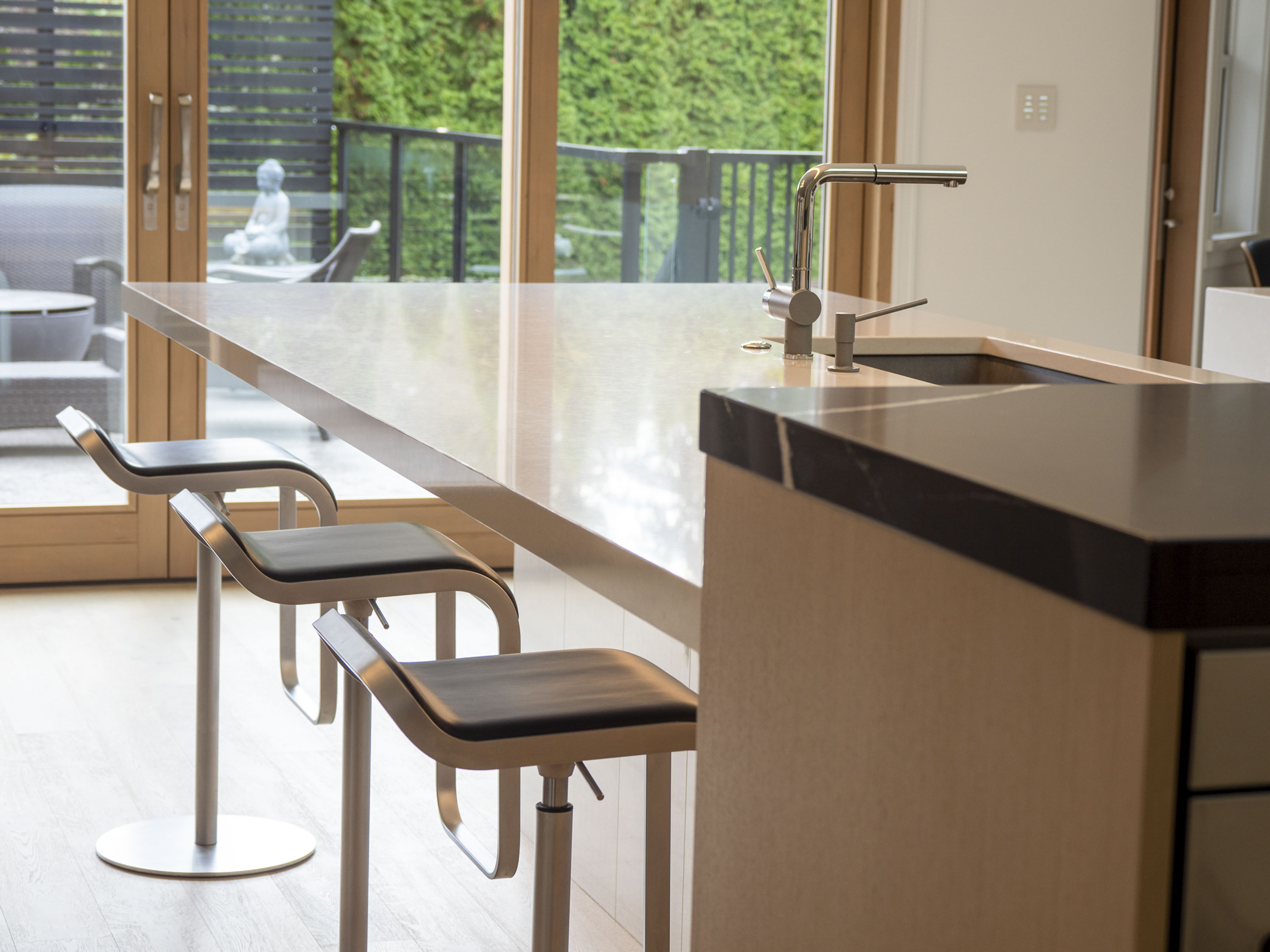 Custom kitchen island renovation Victoria BC - white quartz countertops with modern bar stools and garden views in Delmonte home remodel by Outlook Project Management