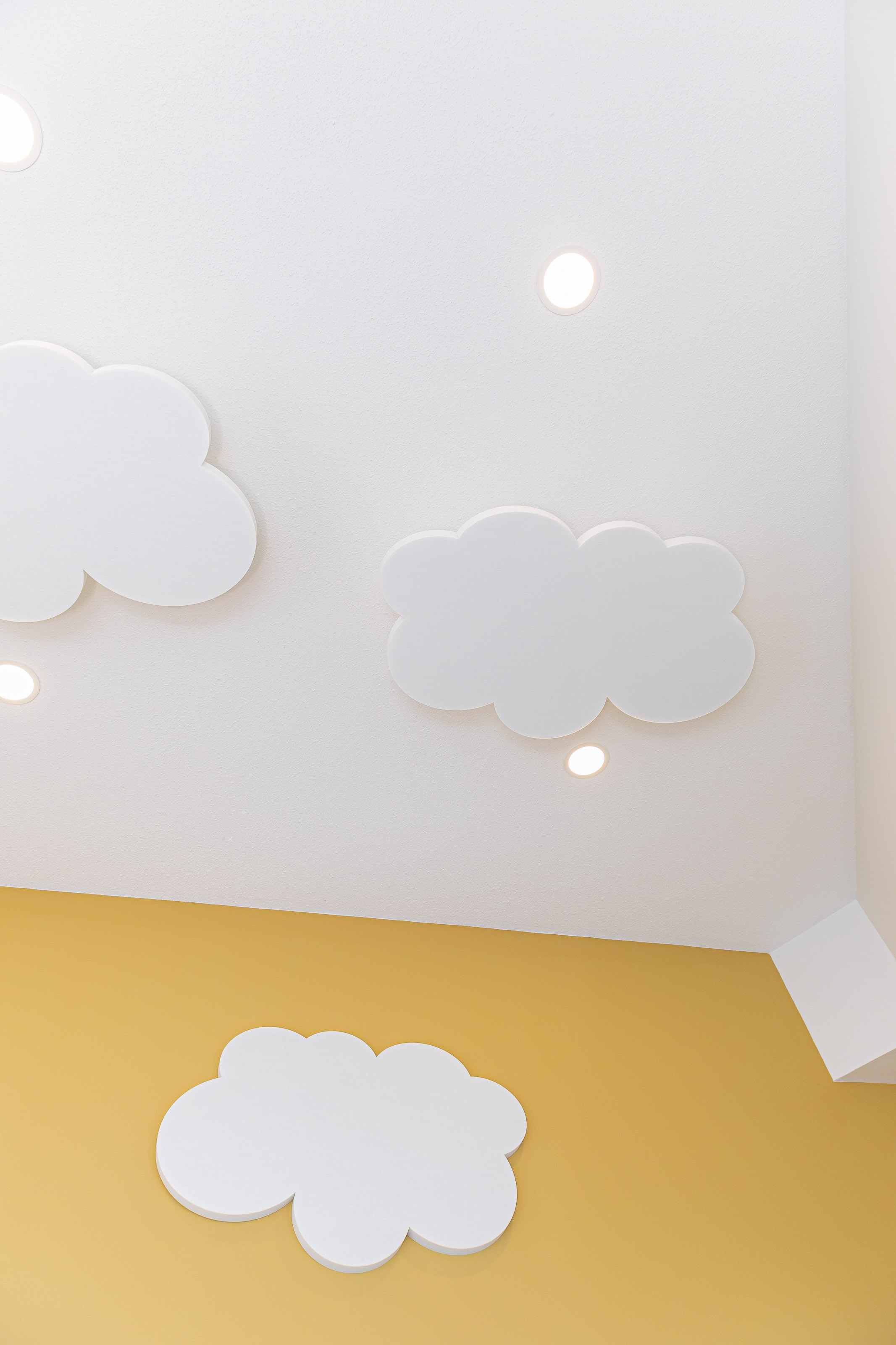 Children's activity room renovation Victoria BC - cultural family center by Outlook Project Management featuring white cloud ceiling design, LED lighting, and bright yellow accent walls