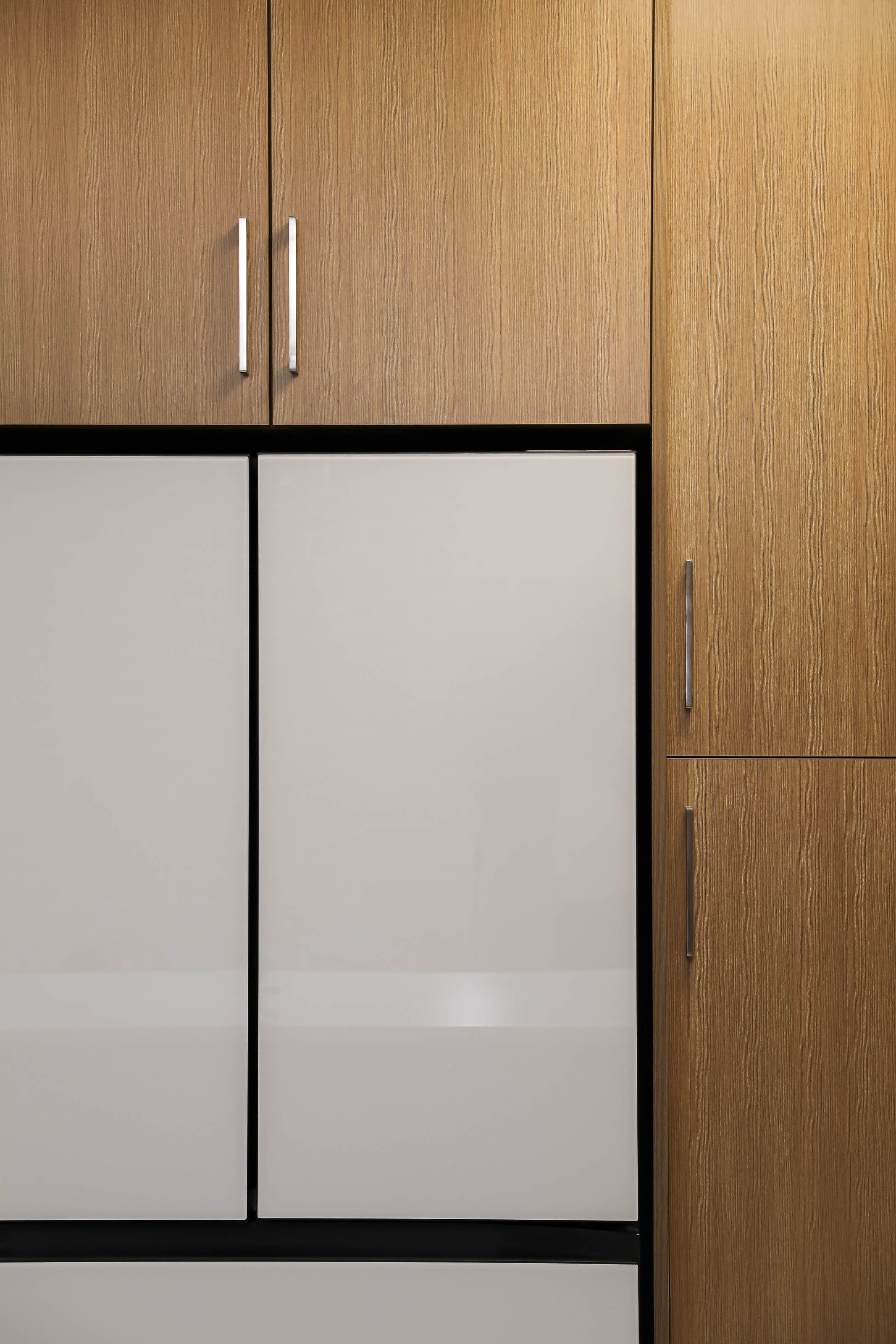 Custom cabinetry detail Victoria BC - Outlook Project Management Coastline project featuring contemporary wood grain finish with white panel inserts and modern hardware