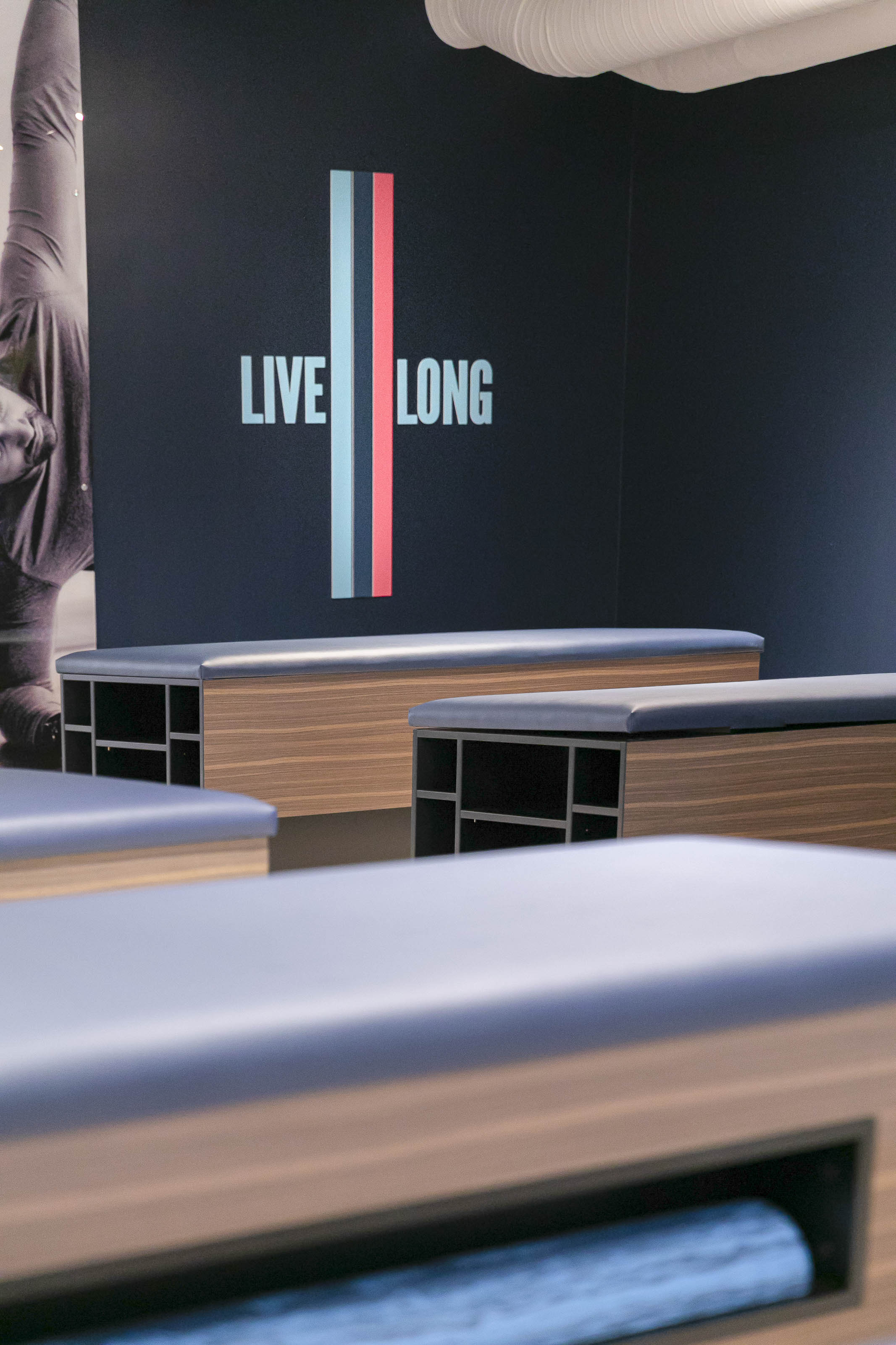 Motivational fitness studio design Victoria BC - Outlook Project Management Stretch Lab commercial construction featuring "Live Long" branding, custom workout benches, and wellness facility interior