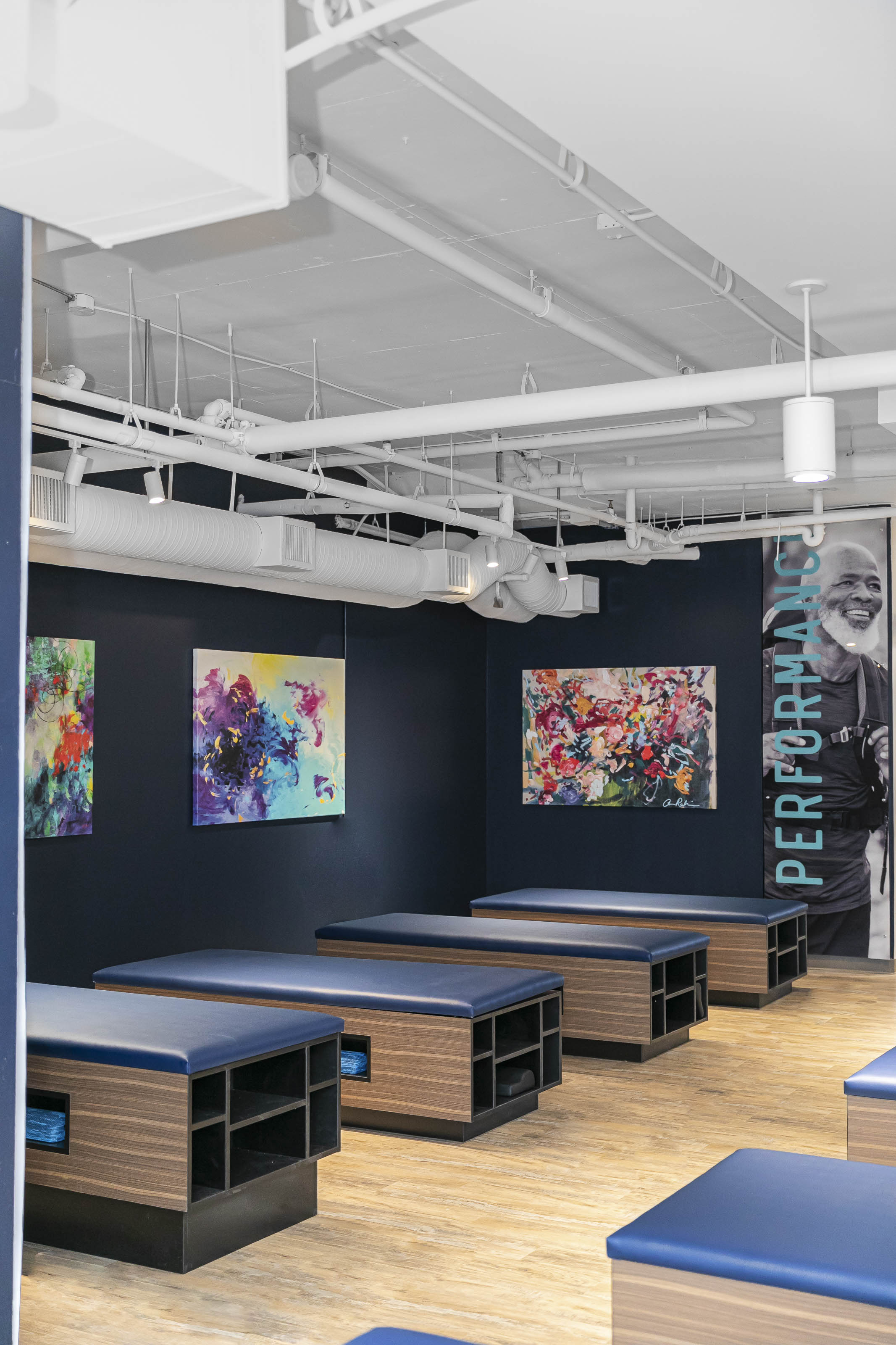 Modern fitness facility reception area Victoria BC - Outlook Project Management Stretch Lab commercial construction featuring custom reception desk, colorful abstract art, exposed ceiling design, and contemporary lighting