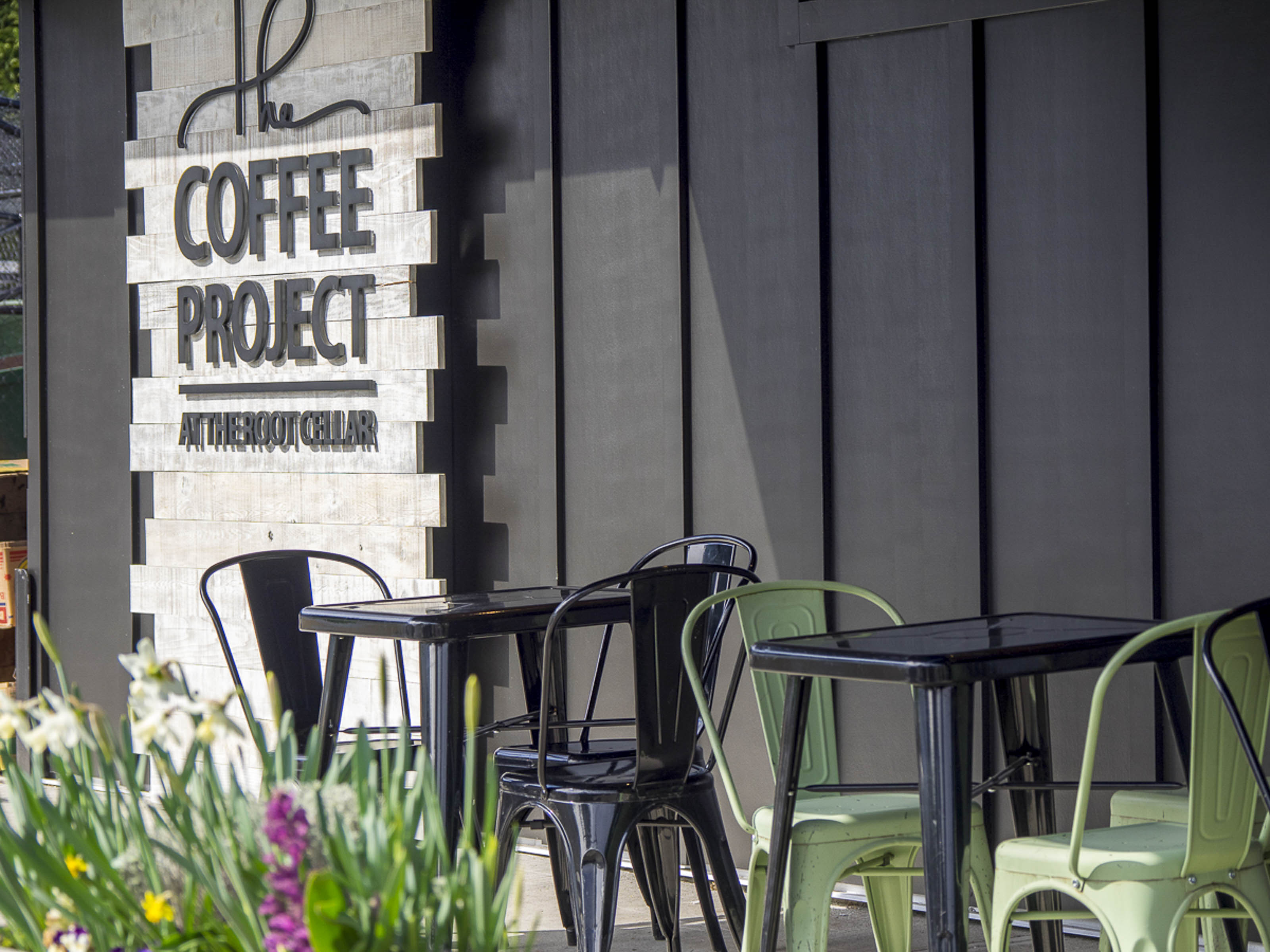 Modern coffee shop exterior construction Victoria BC - Outlook Project Management Coffee Project tenant improvement featuring contemporary signage, outdoor patio, wooden ceiling design, and commercial restaurant build-out